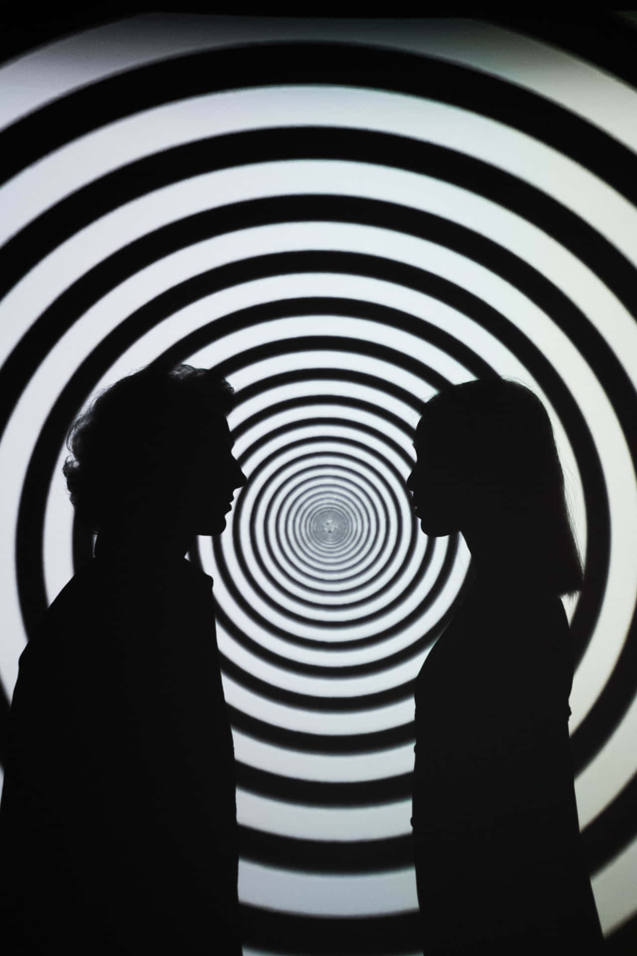 To silhouette af mennesker, der står foran en spiralgalakse Wallpaper