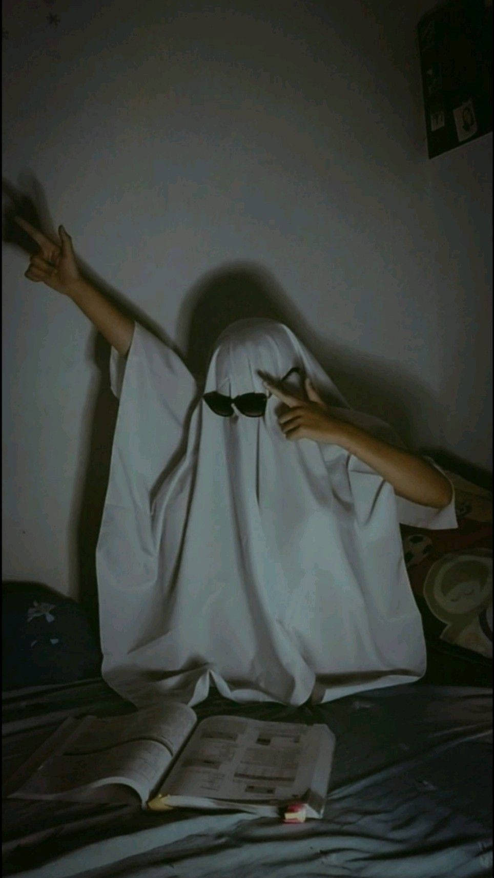 A Person In A White Ghost Costume Is Sitting On A Bed Wallpaper