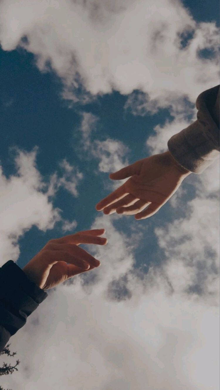 To hænder når op til hinanden i himlen Wallpaper