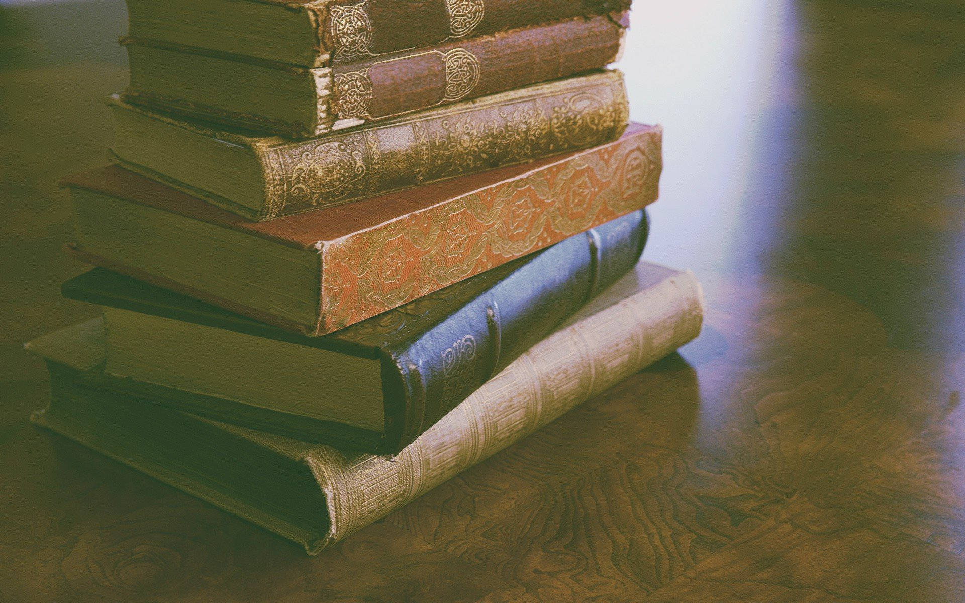 A Stack Of Books On A Table Wallpaper