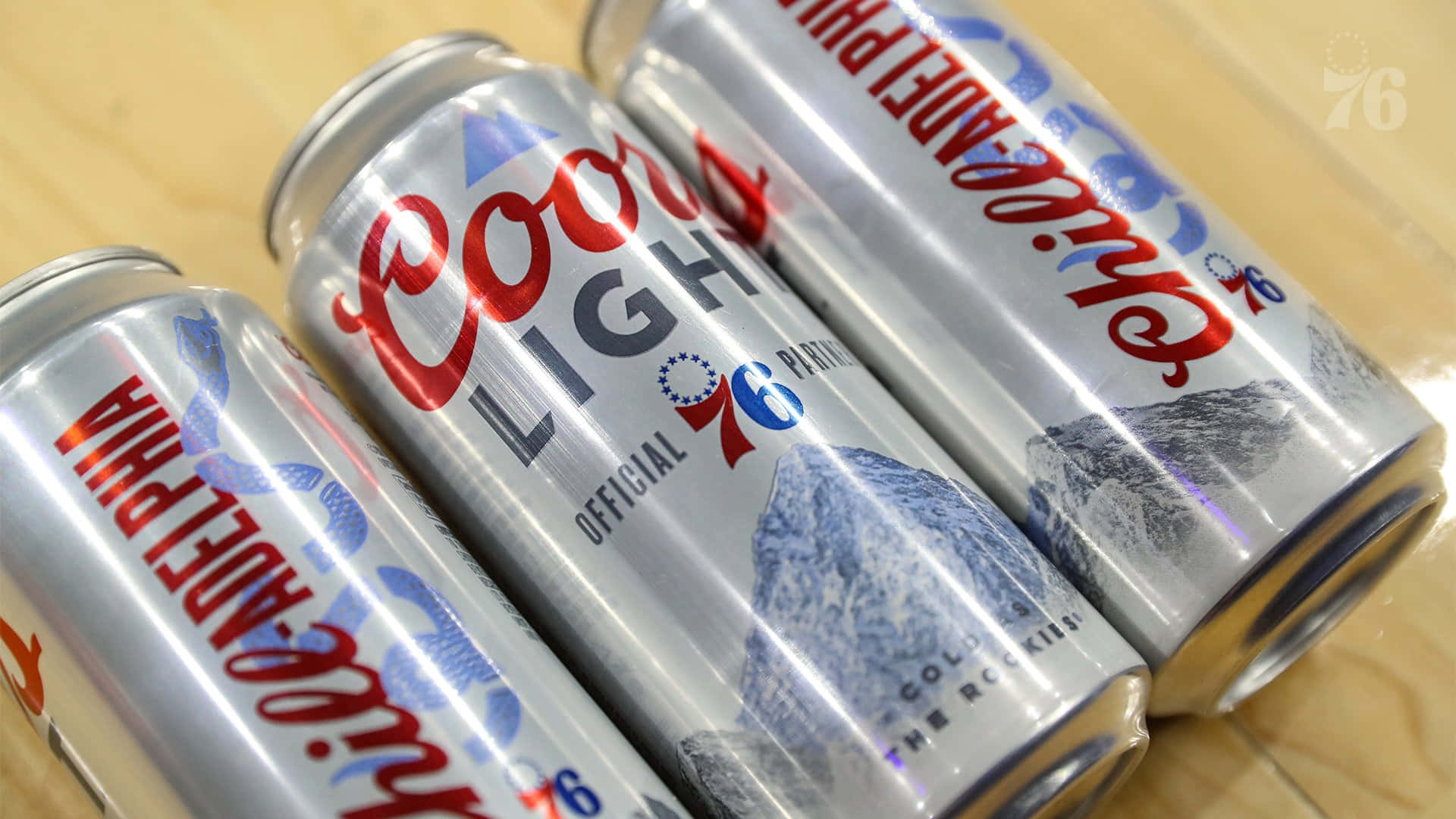 Three Coors Light Beer Cans Lain On A Wooden Surface Wallpaper