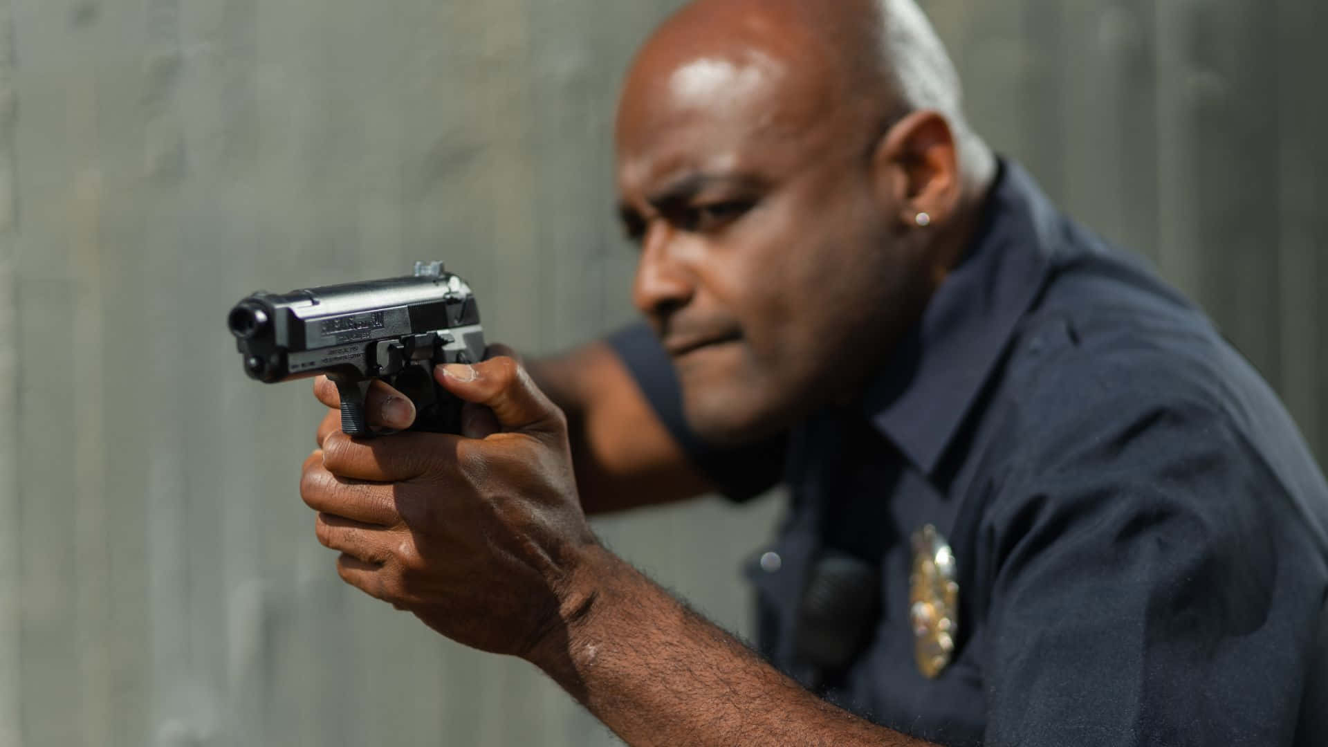 En politibetjent, der sigter sin pistol mod en væg Wallpaper