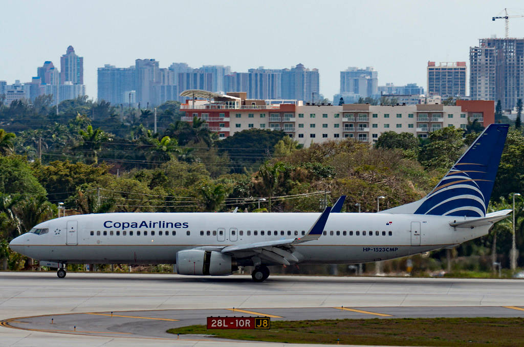 Aviónde Copa Airlines Con Edificios Y Árboles. Fondo de pantalla