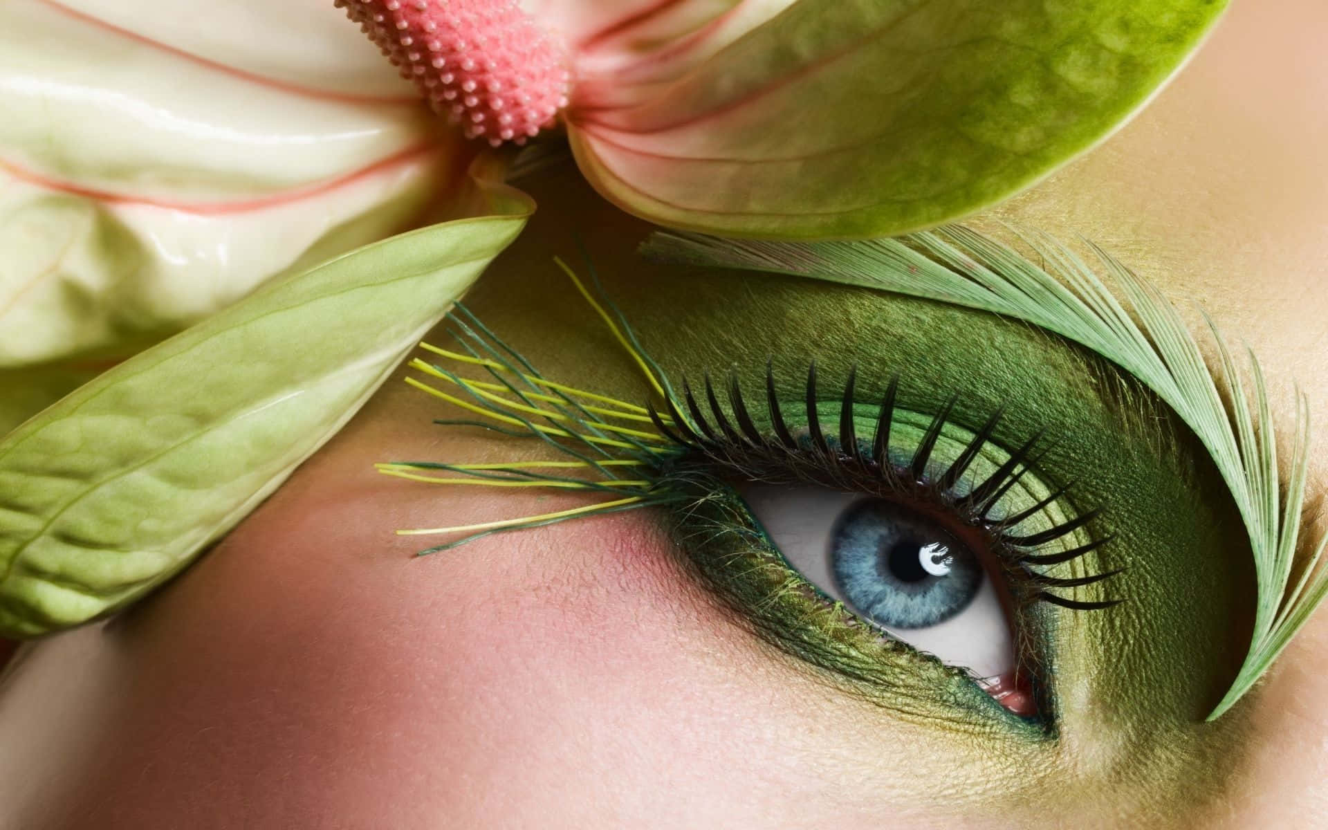 A Woman's Eye With Green Makeup And Feathers