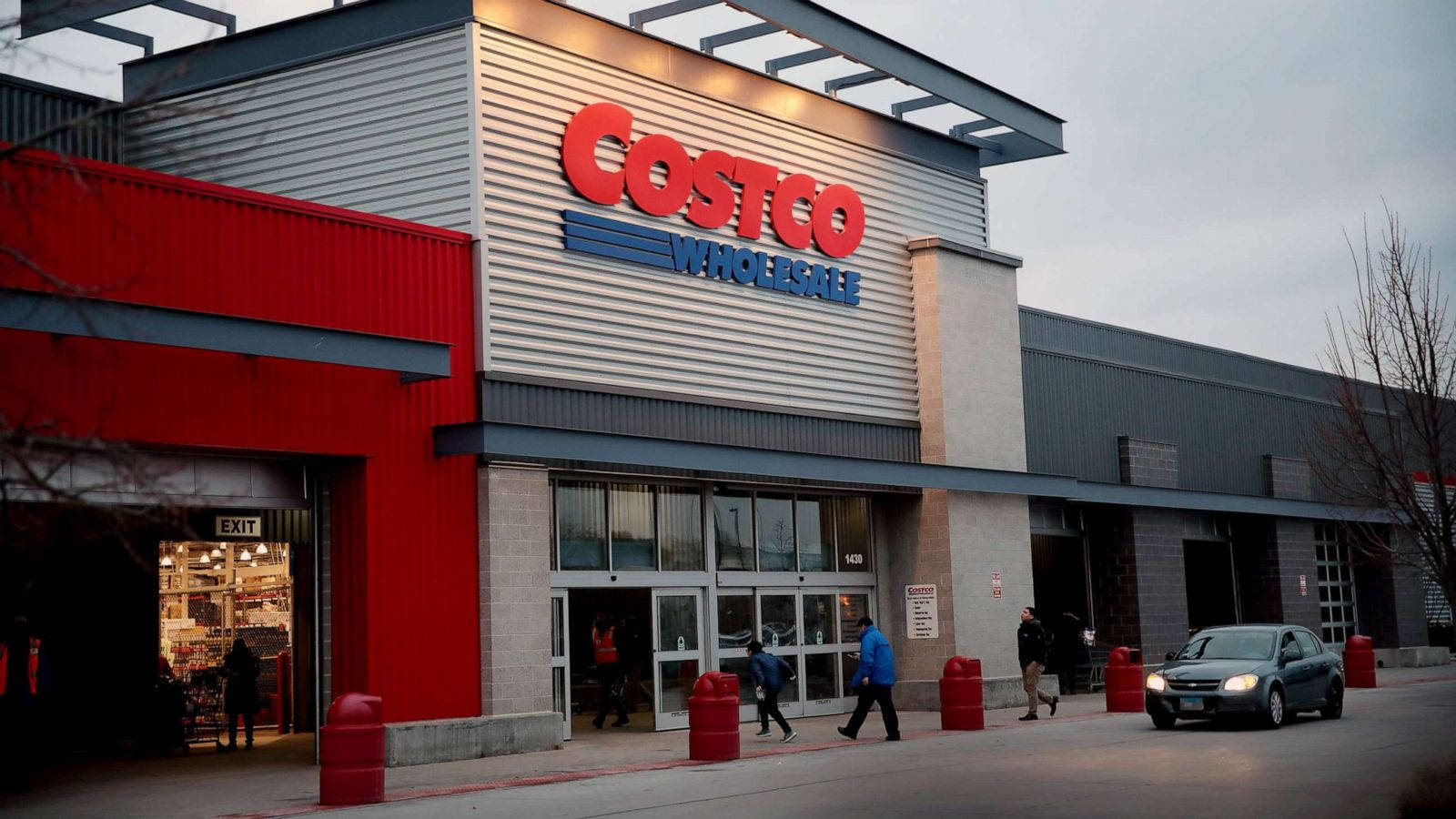 A bustling Costco Wholesale Store with a black car parked at the front Wallpaper