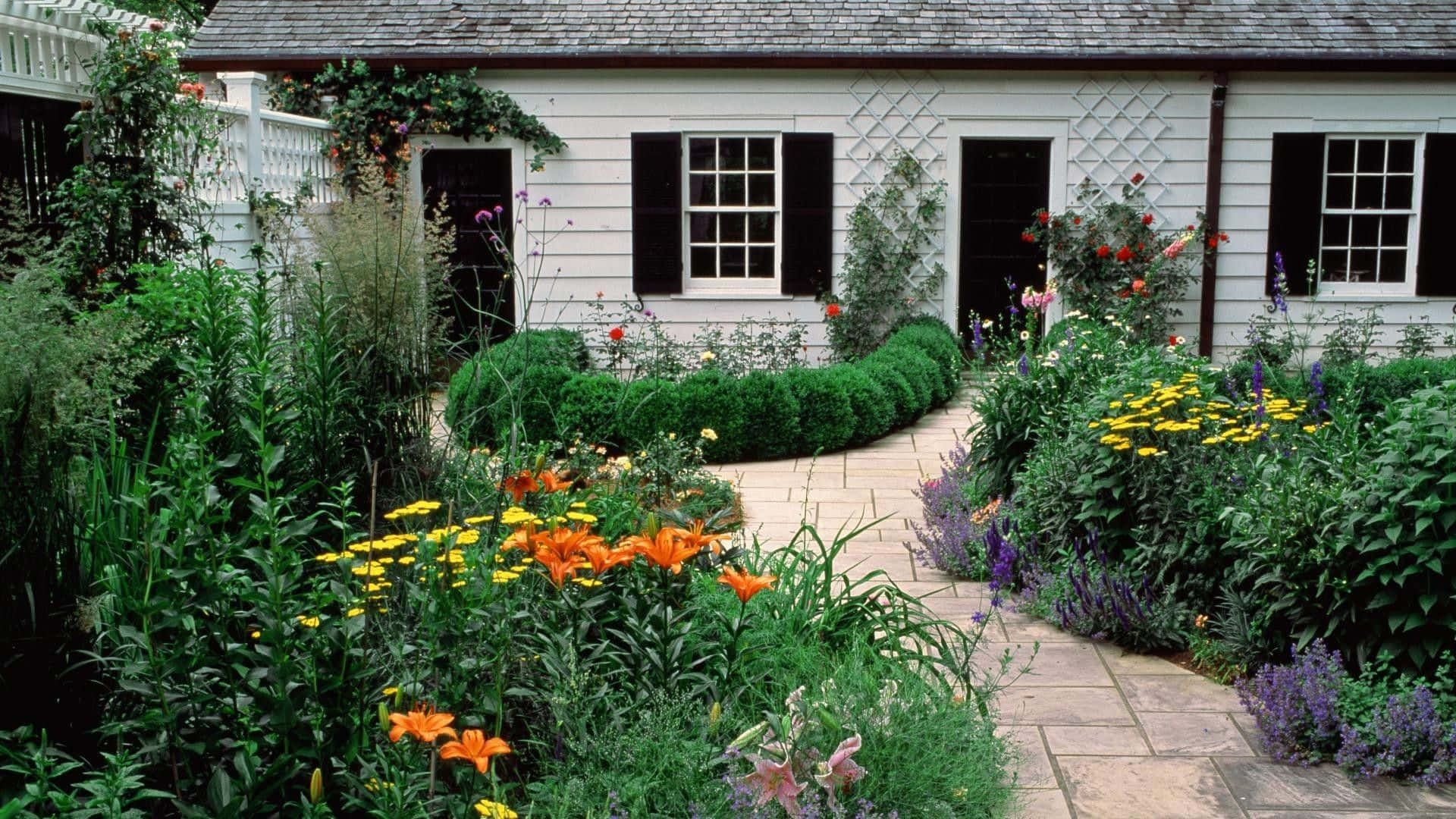 Enchanting Cottage Garden with Colorful Blooms and Stone Pathway Wallpaper