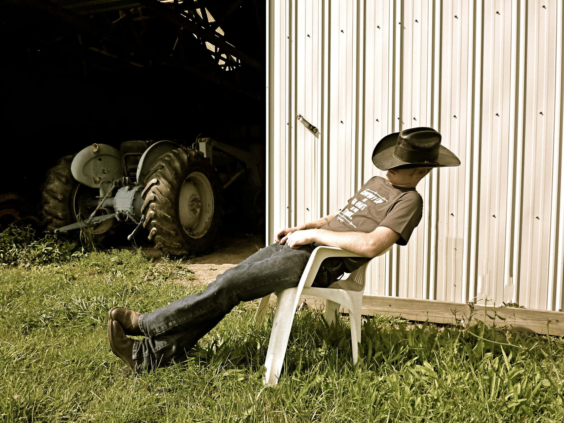 Country Boy Resting Beside Barn Wallpaper