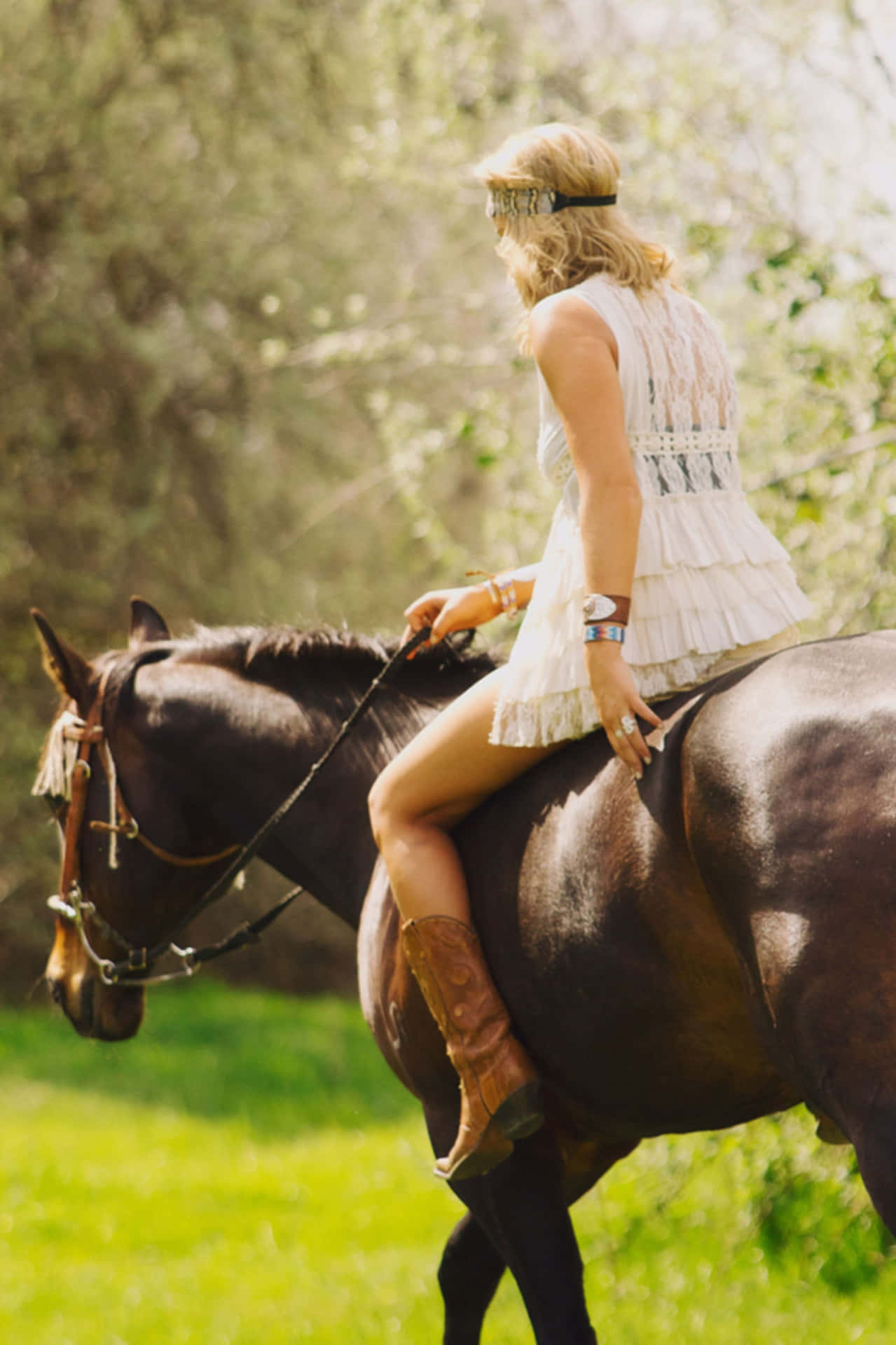 En kvinde rider en hest i et felt Wallpaper
