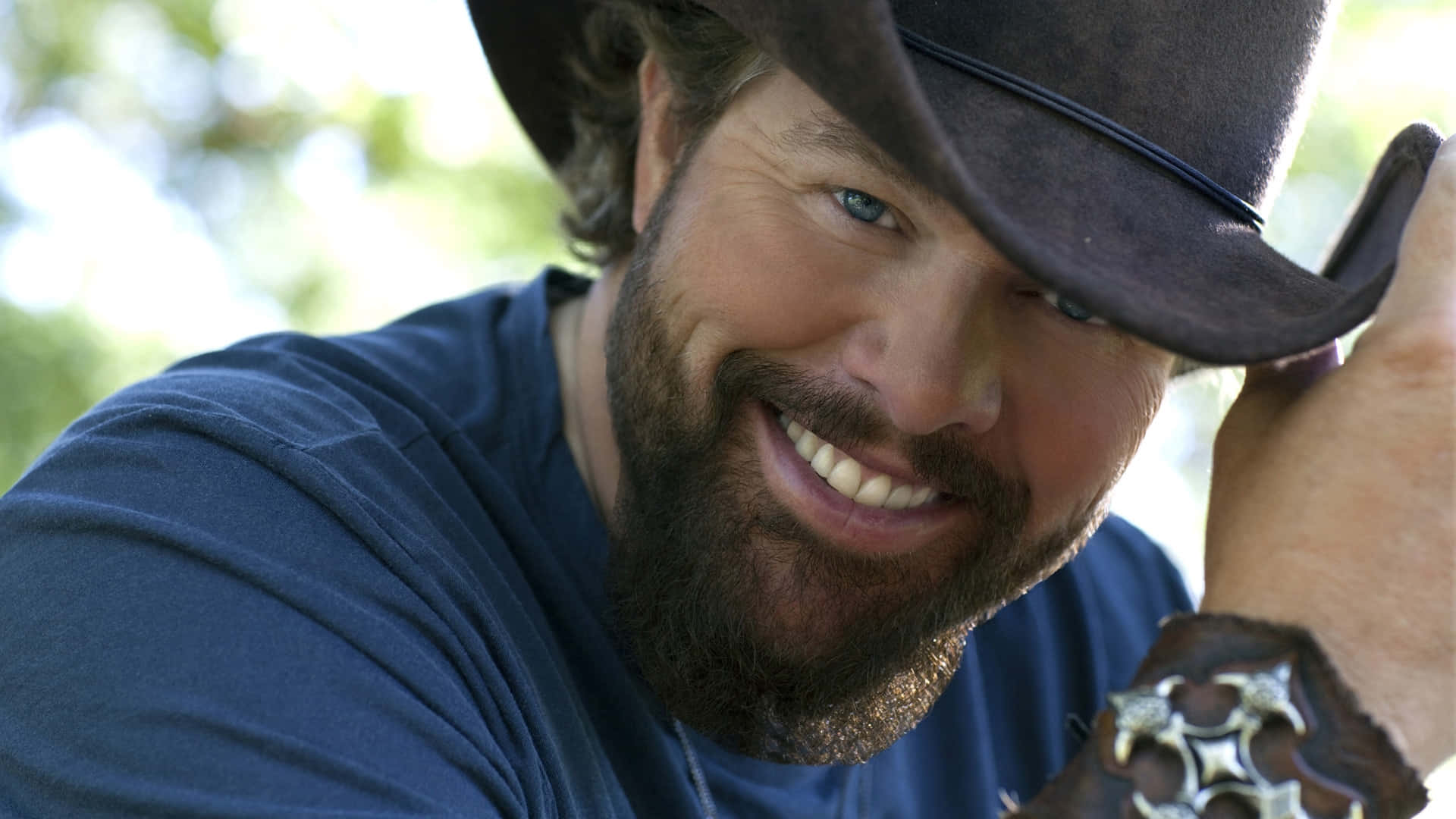 Country Music Artist Smiling With Hat Wallpaper