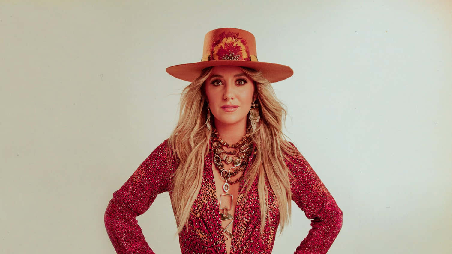 Country Music Artistin Red Glitter Jacketand Brown Hat Wallpaper