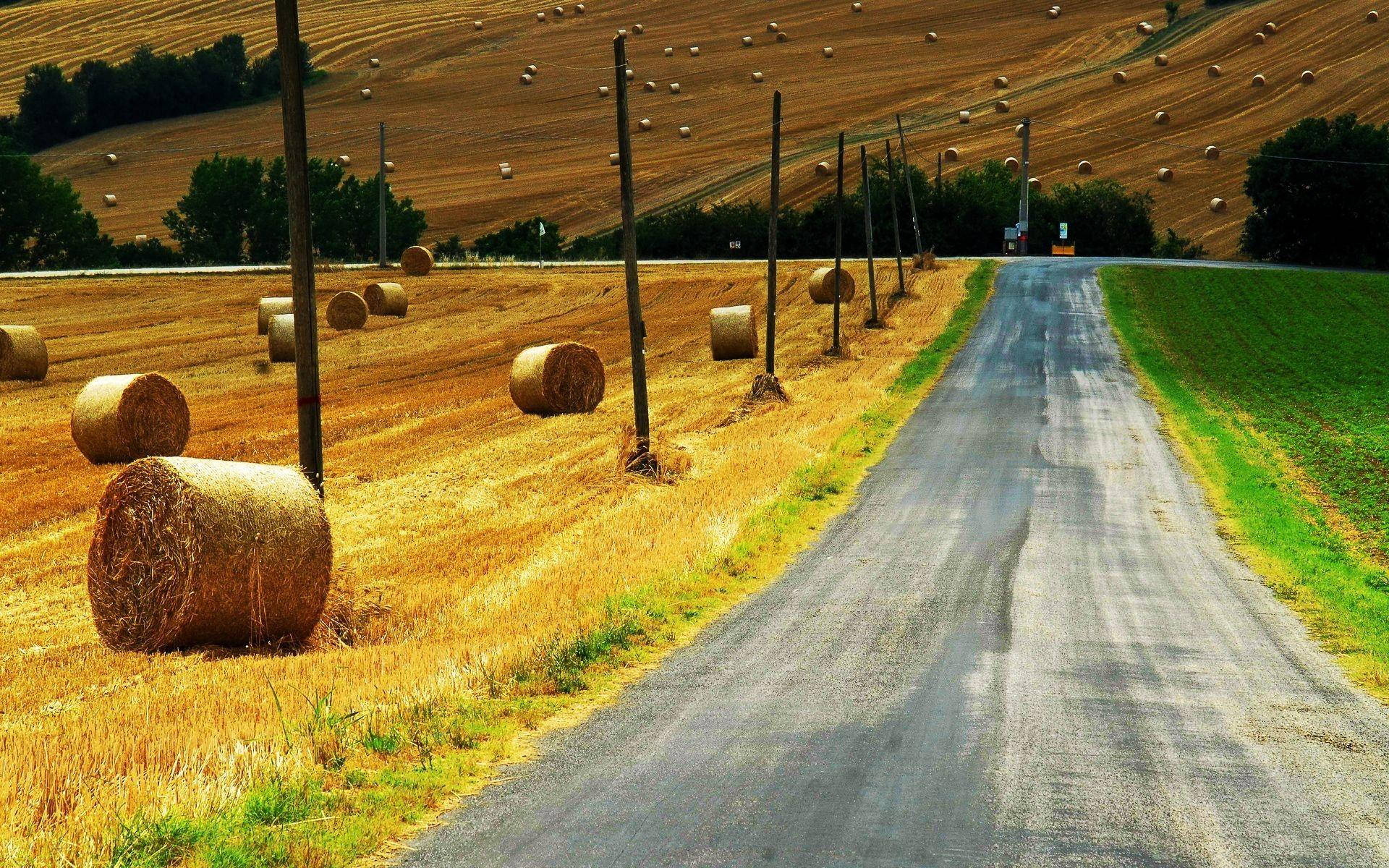Country Road With Rolled Up Haystack Wallpaper