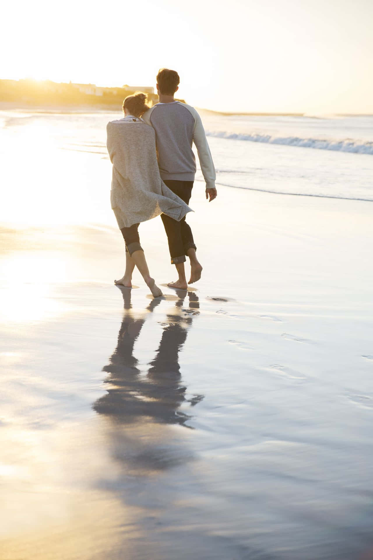 Couple At Beach Walking On Wet Sand During Sunset Picture