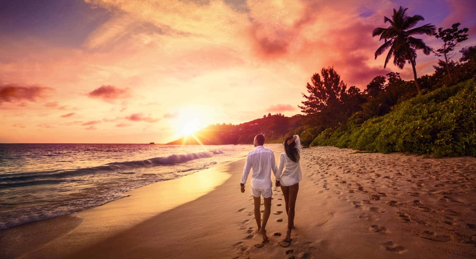 Couple At Beach Walking Near Palm Trees At Sunset Picture