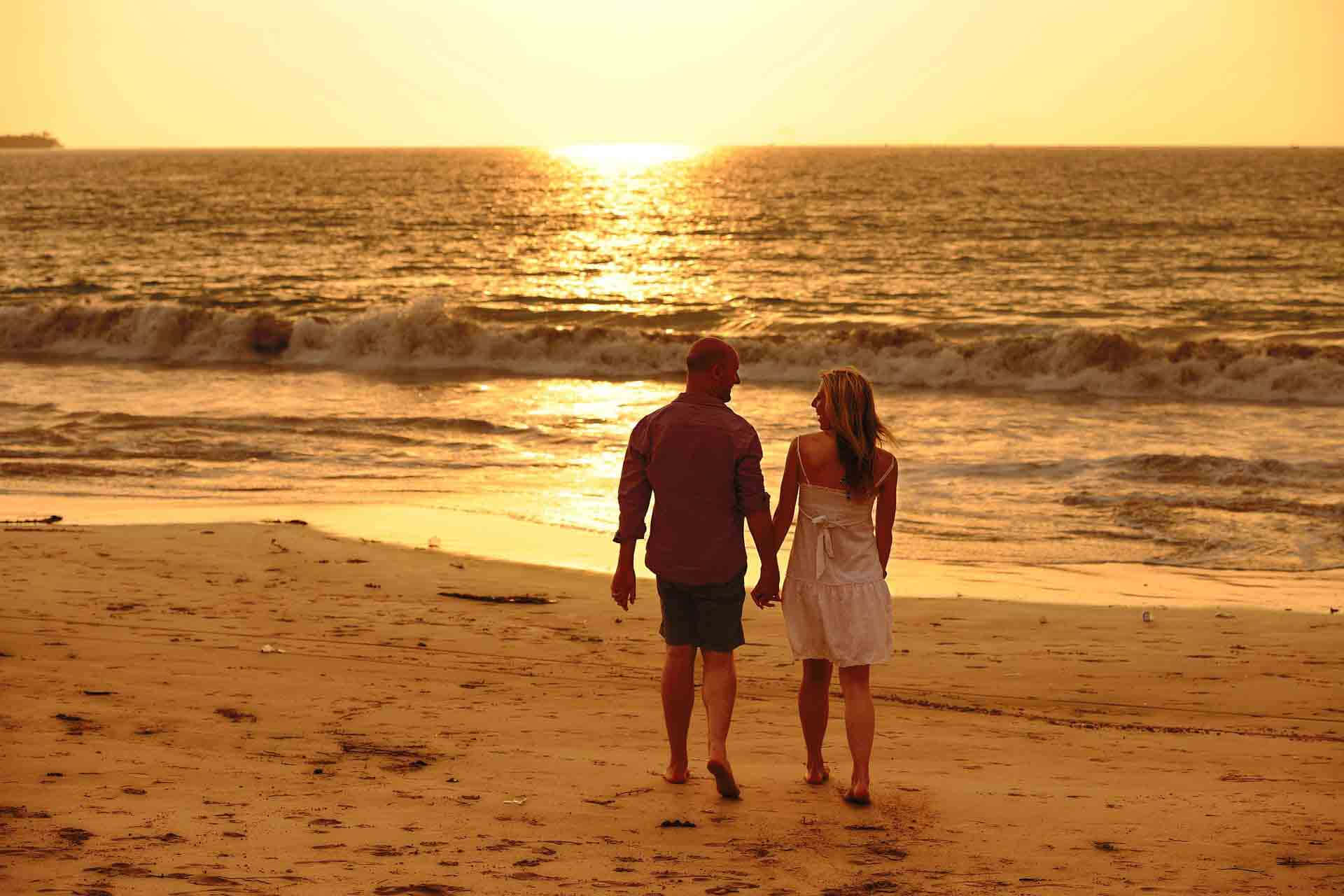 Couple At Beach Holding Hands Watching The Horizon Picture
