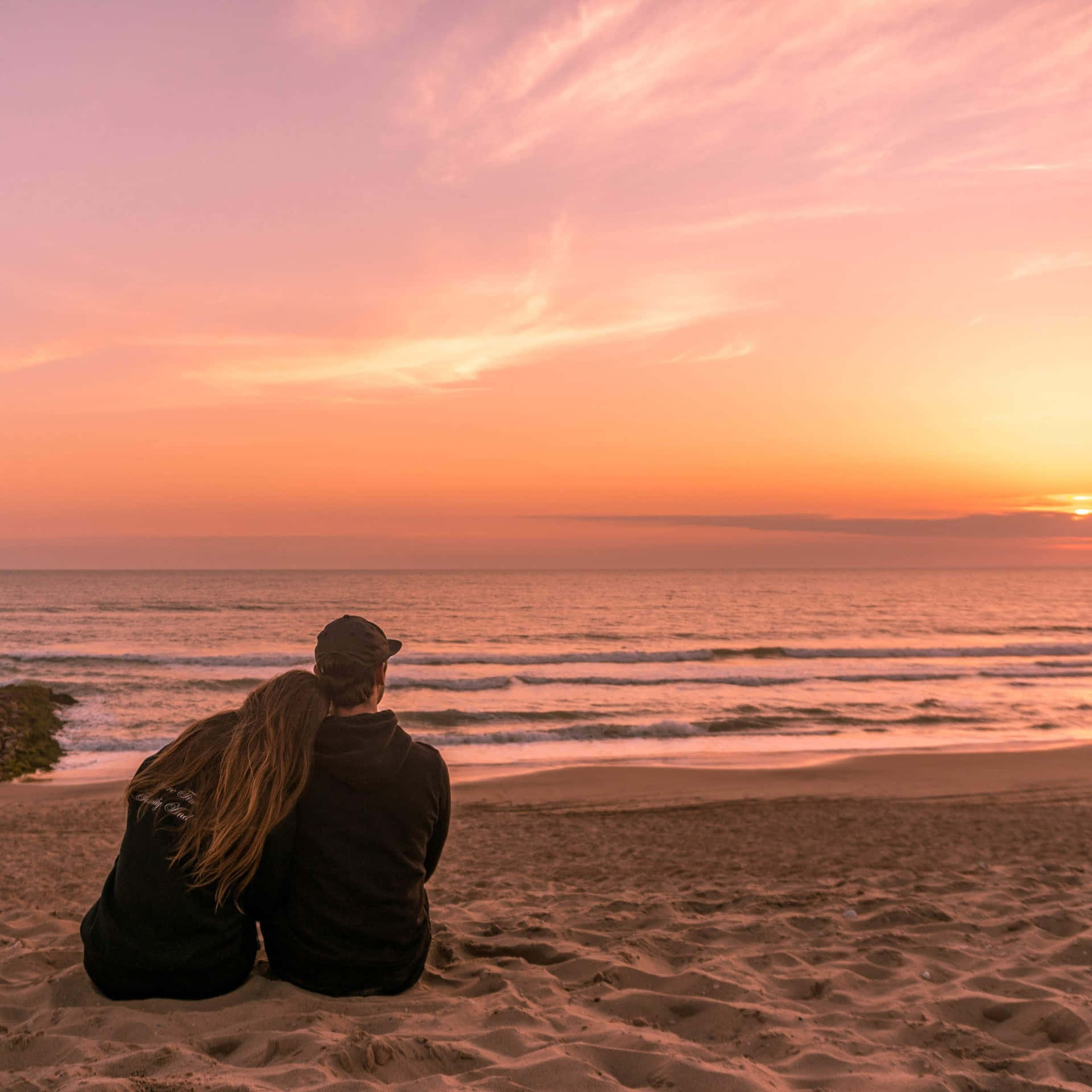 Couple At Beach Sitting On Sand During Sunset Picture