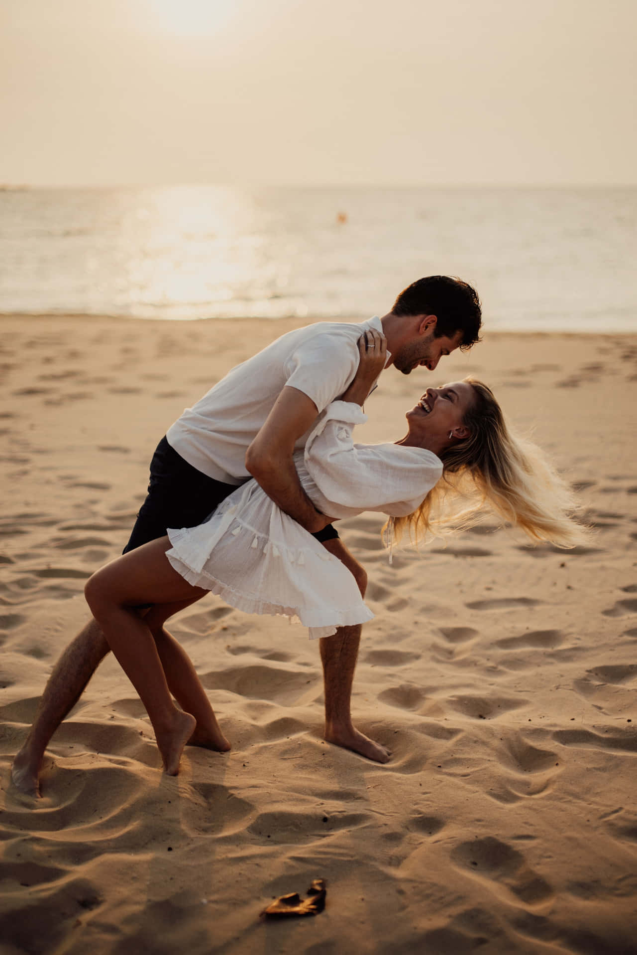 Download Couple At Beach Playful Pose Wallpaper
