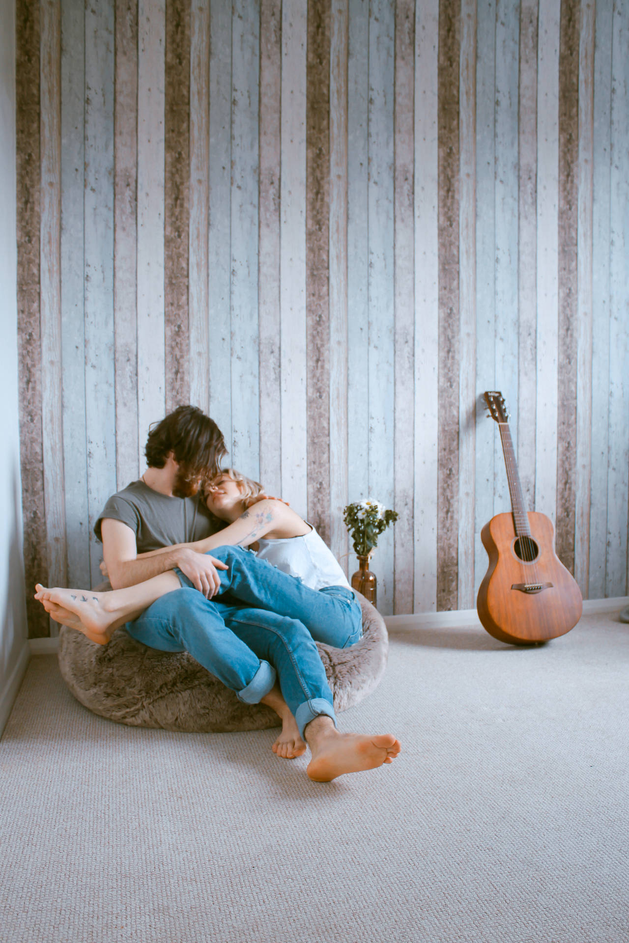 Couple Cuddling On Beanbag Wallpaper