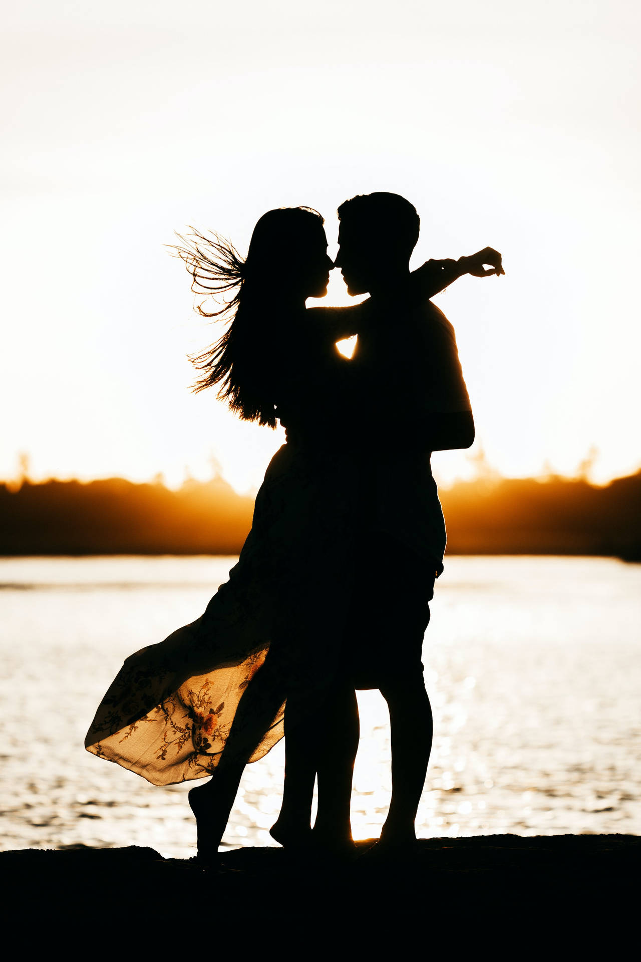 Couple Hugging Beach Silhouette At Sunset Wallpaper