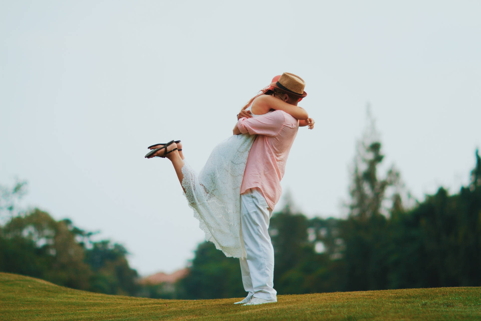 Couple Hugging In Catcher Hug On Green Landscape Wallpaper