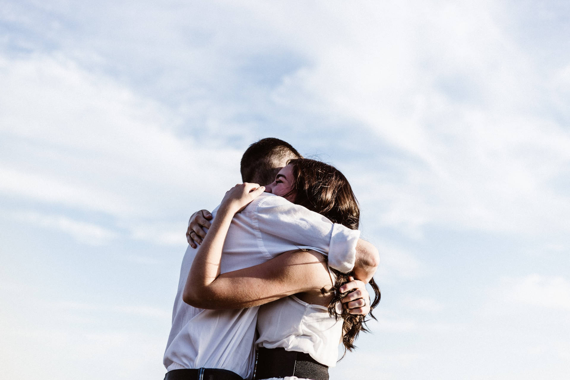 Couple Hugging Passionately On A Sunny Day Wallpaper