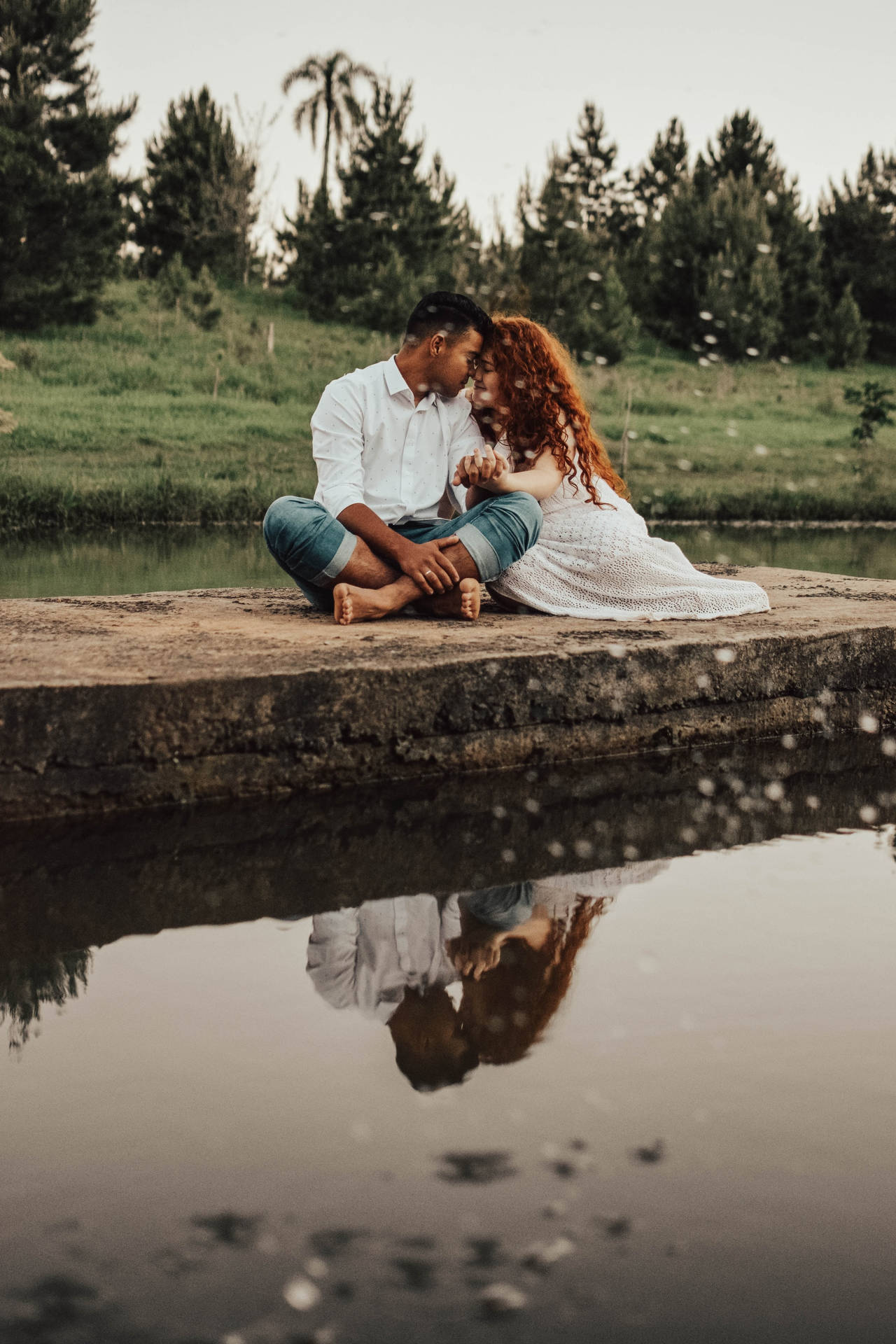 Couple Hugging With Reflection By The River Wallpaper
