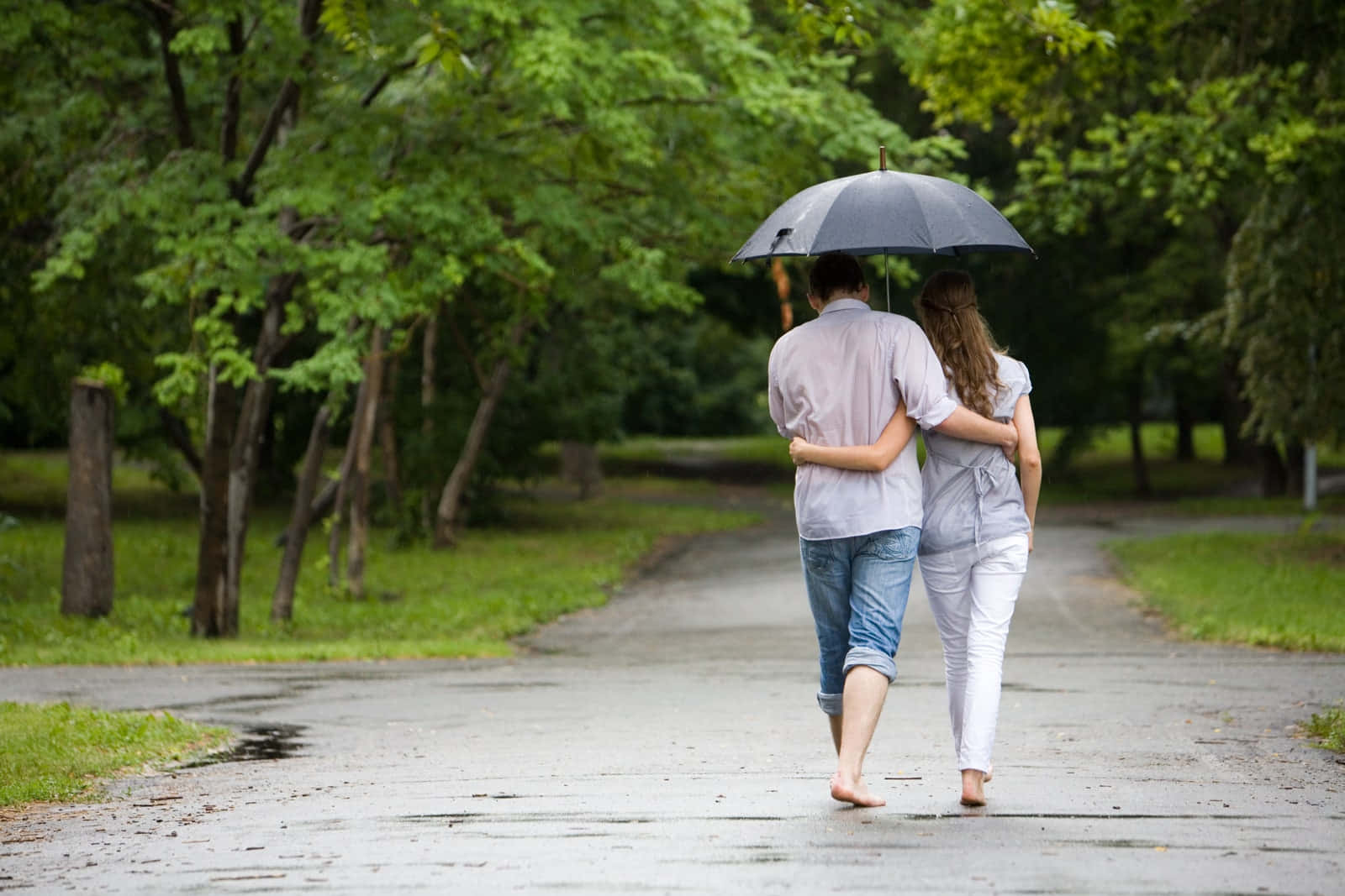 Download Couple Walking Under An Umbrella In The Rain