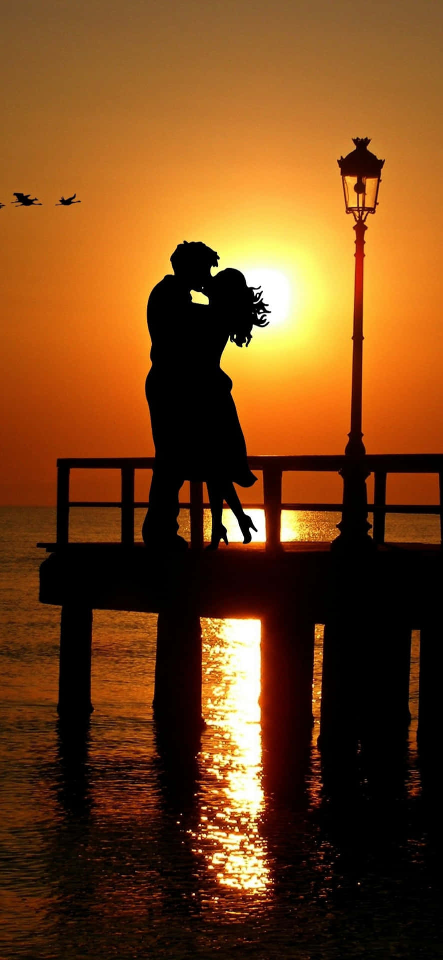 Par kysse på kajen solnedgang billede tapet