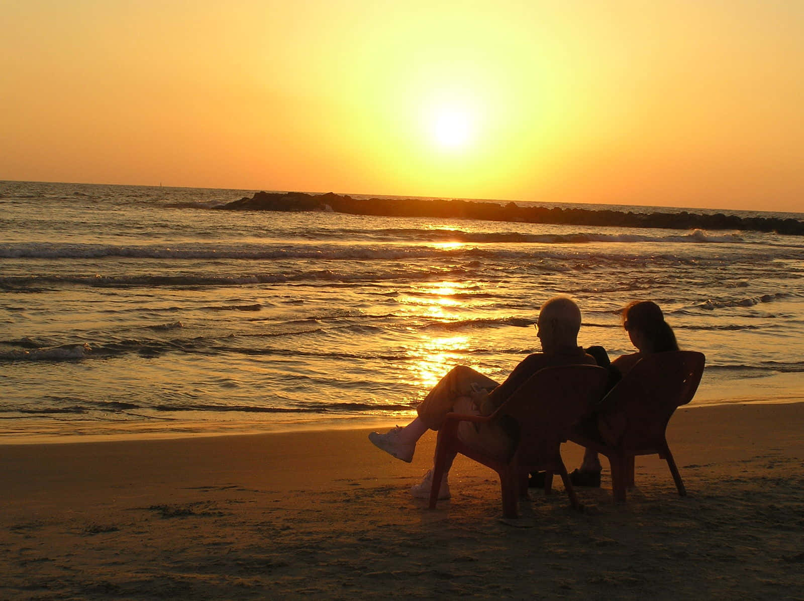 Bildeines Paares Beim Sonnenuntergang Auf Stühlen Am Strand