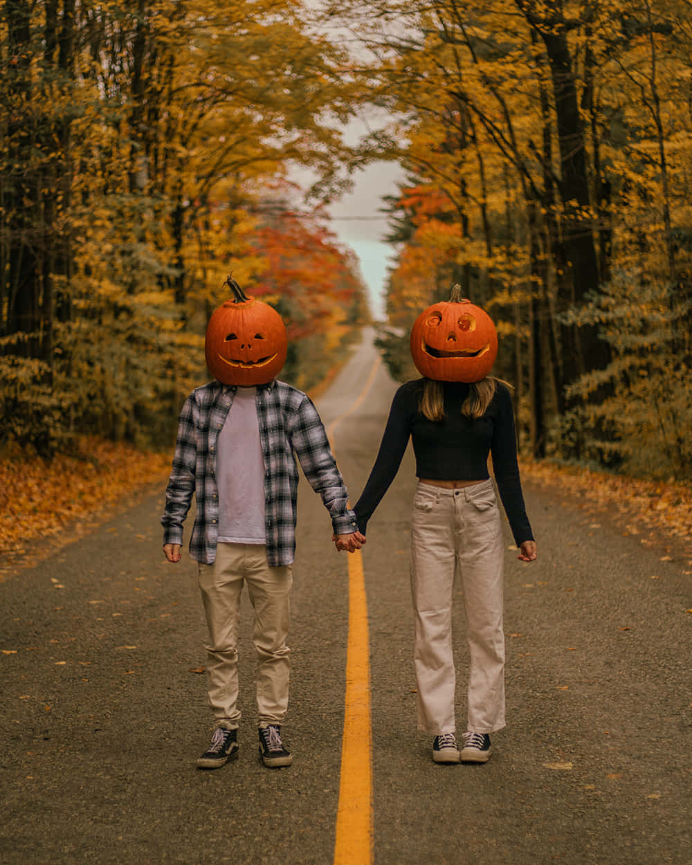 "Couple Embracing Autumn Halloween Spirit with Jack-o'-Lantern Masks" Wallpaper