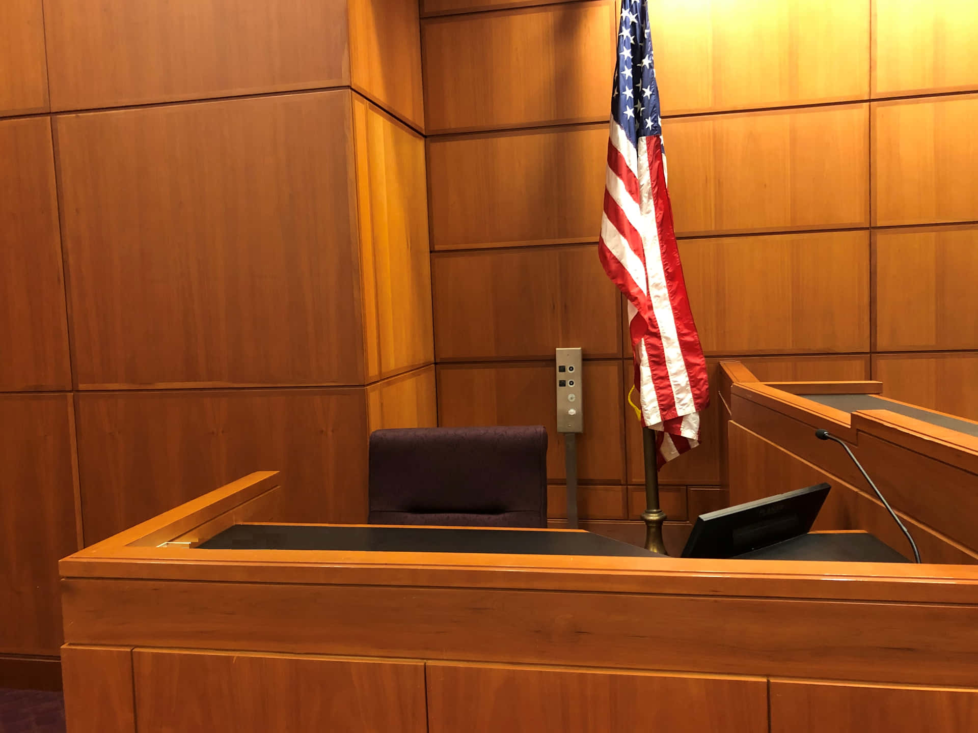 A Courtroom With A Desk And A Flag