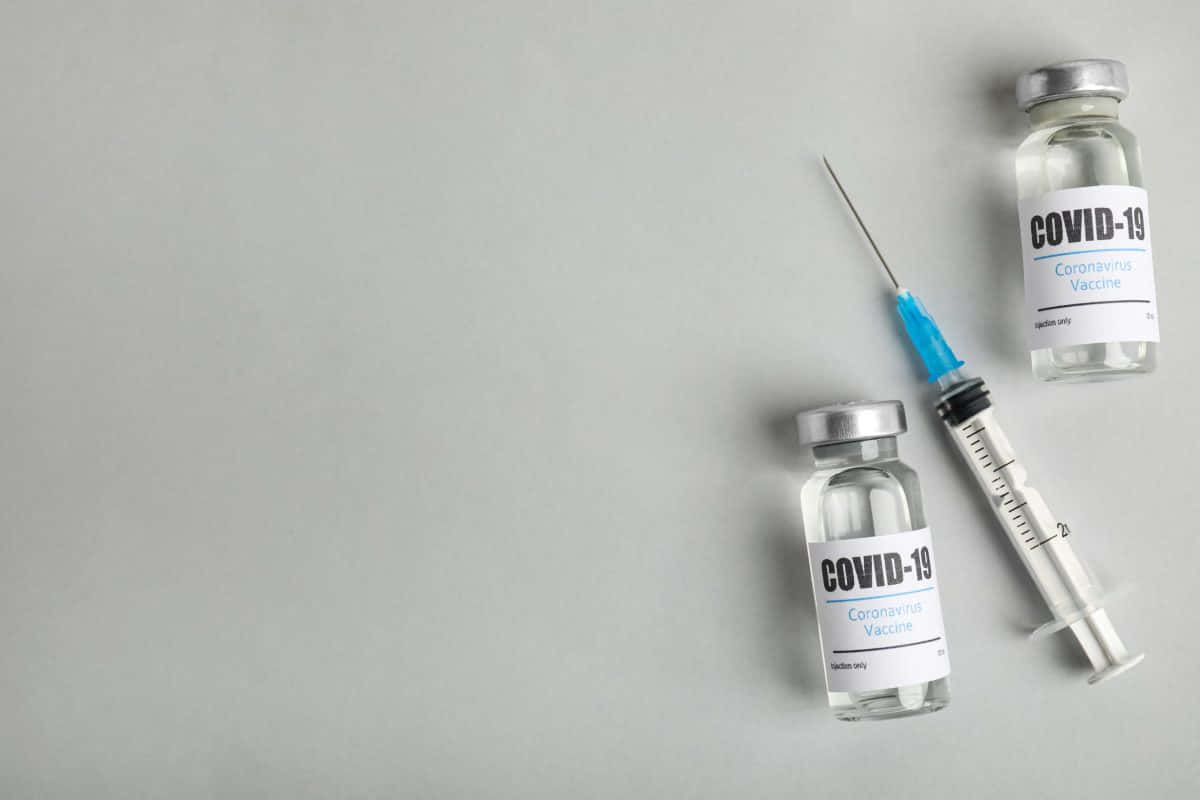 Covid-19 Vaccine Vials And Syringe Plain Background