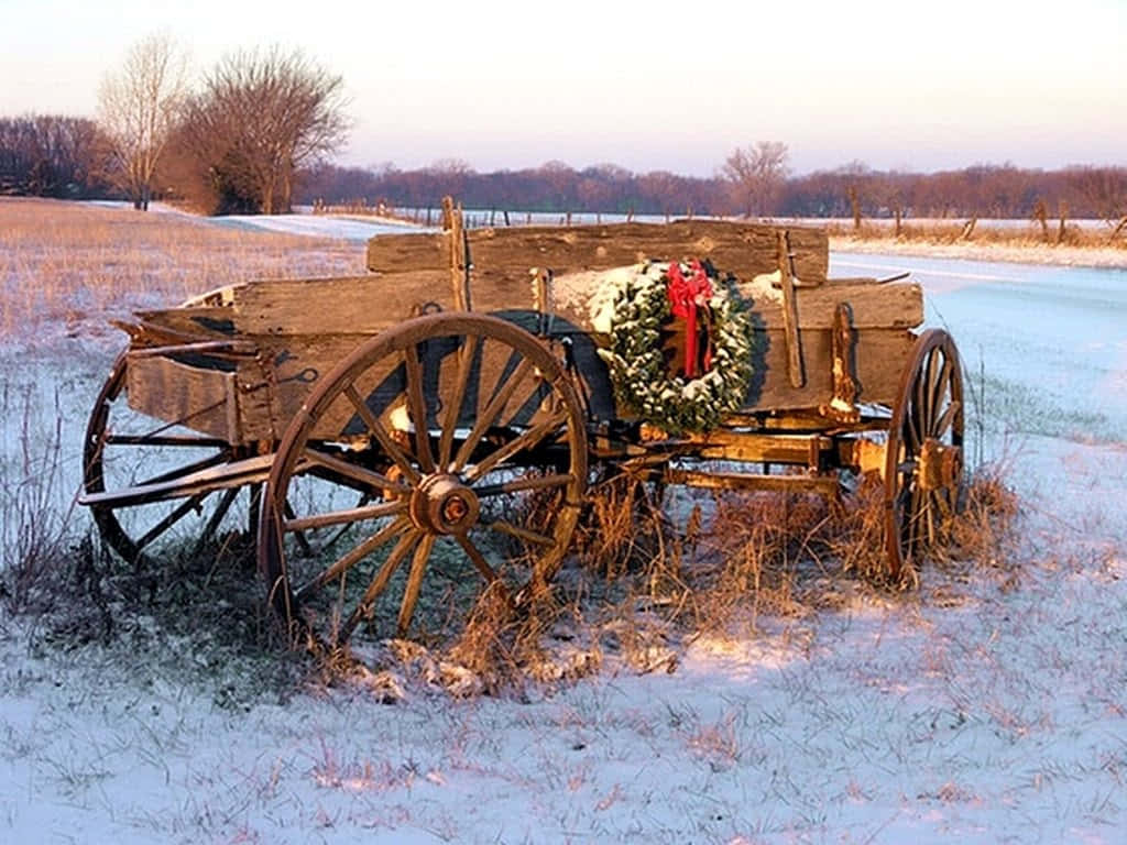 An Old Wagon With A Wreath On It In The Snow Wallpaper
