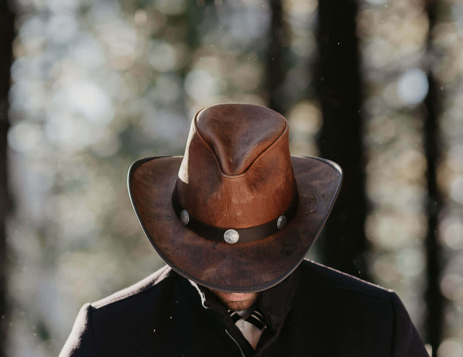 A Man Wearing A Cowboy Hat In The Woods