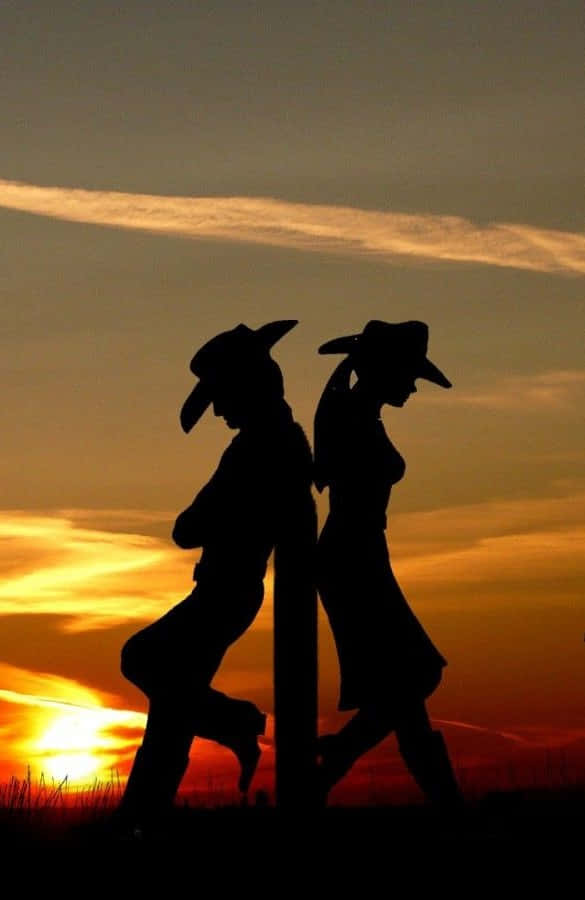 To silhouette af et par går i solnedgangen Wallpaper