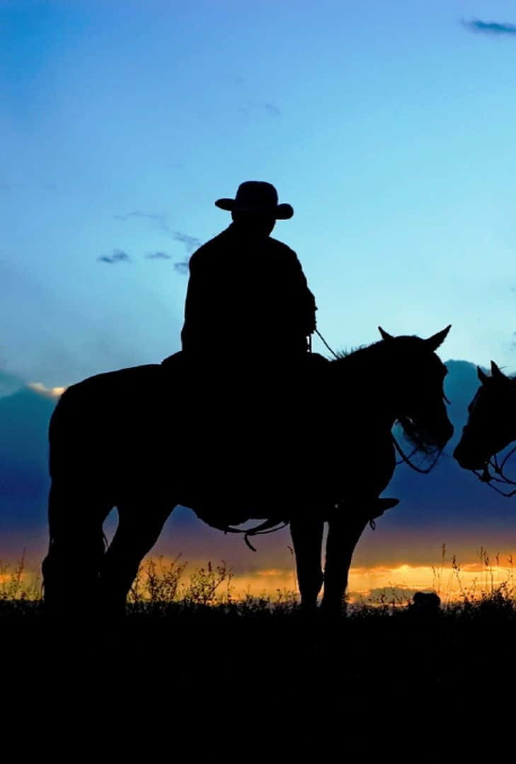 En cowboy som rider ind i solnedgangen med sin iPhone i hånden. Wallpaper