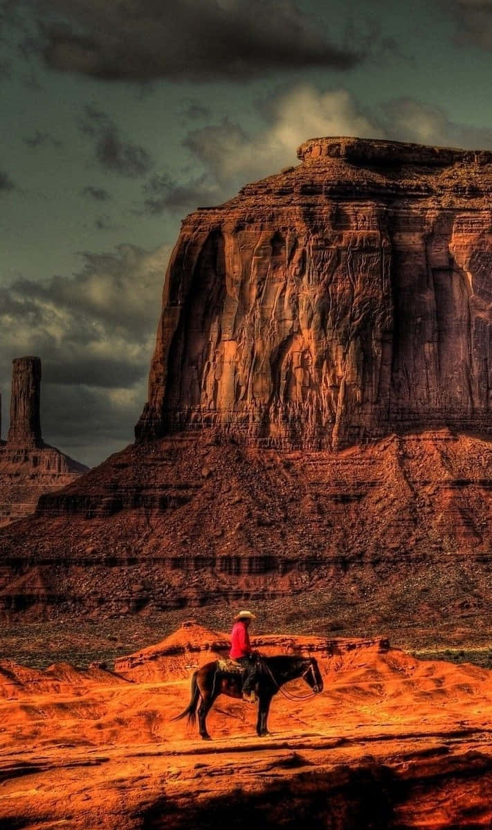 Unvaquero Montando A Caballo En Monument Valley. Fondo de pantalla