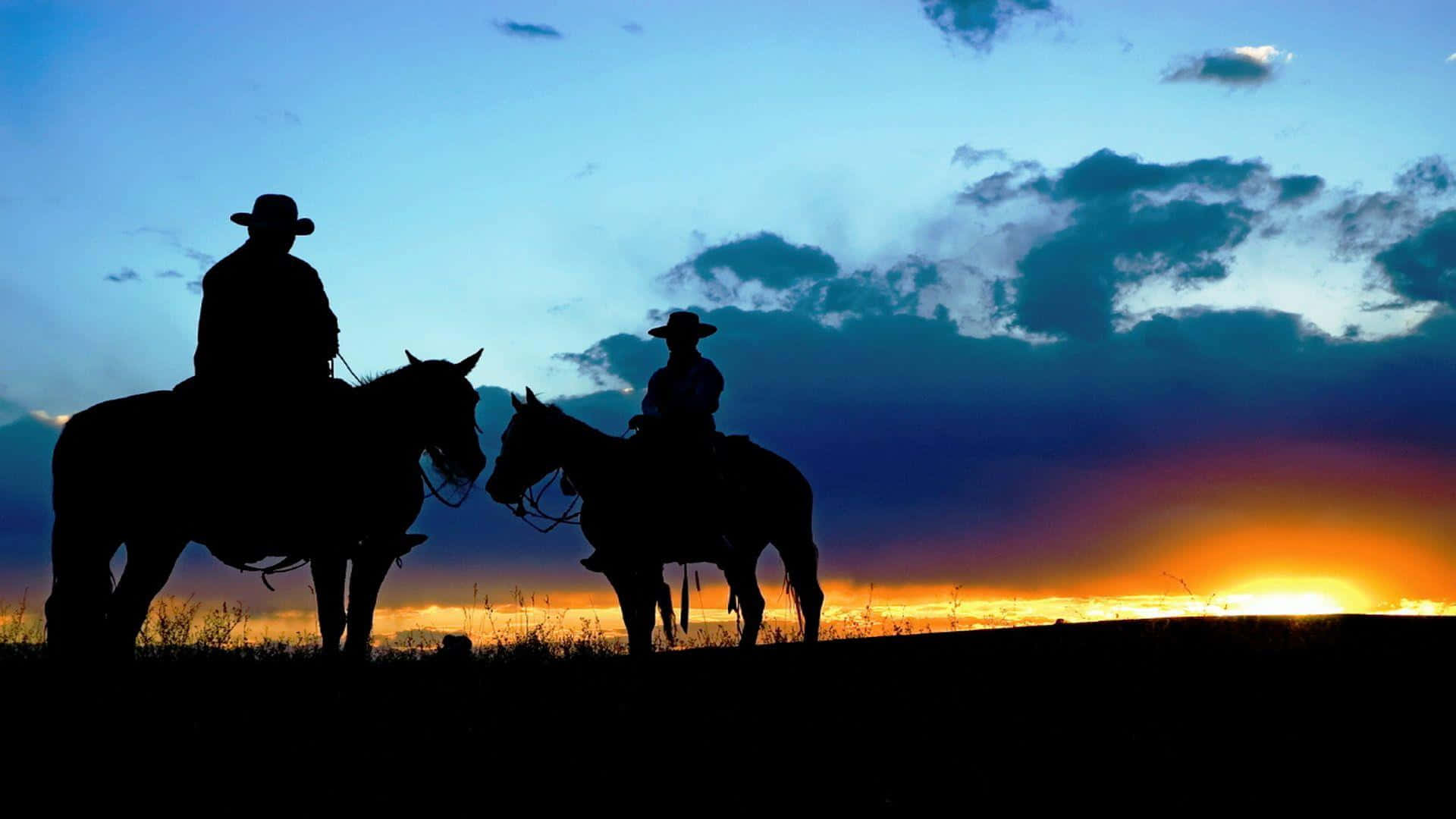 Silhouette of Cowboys Riding on Horseback at Sunset