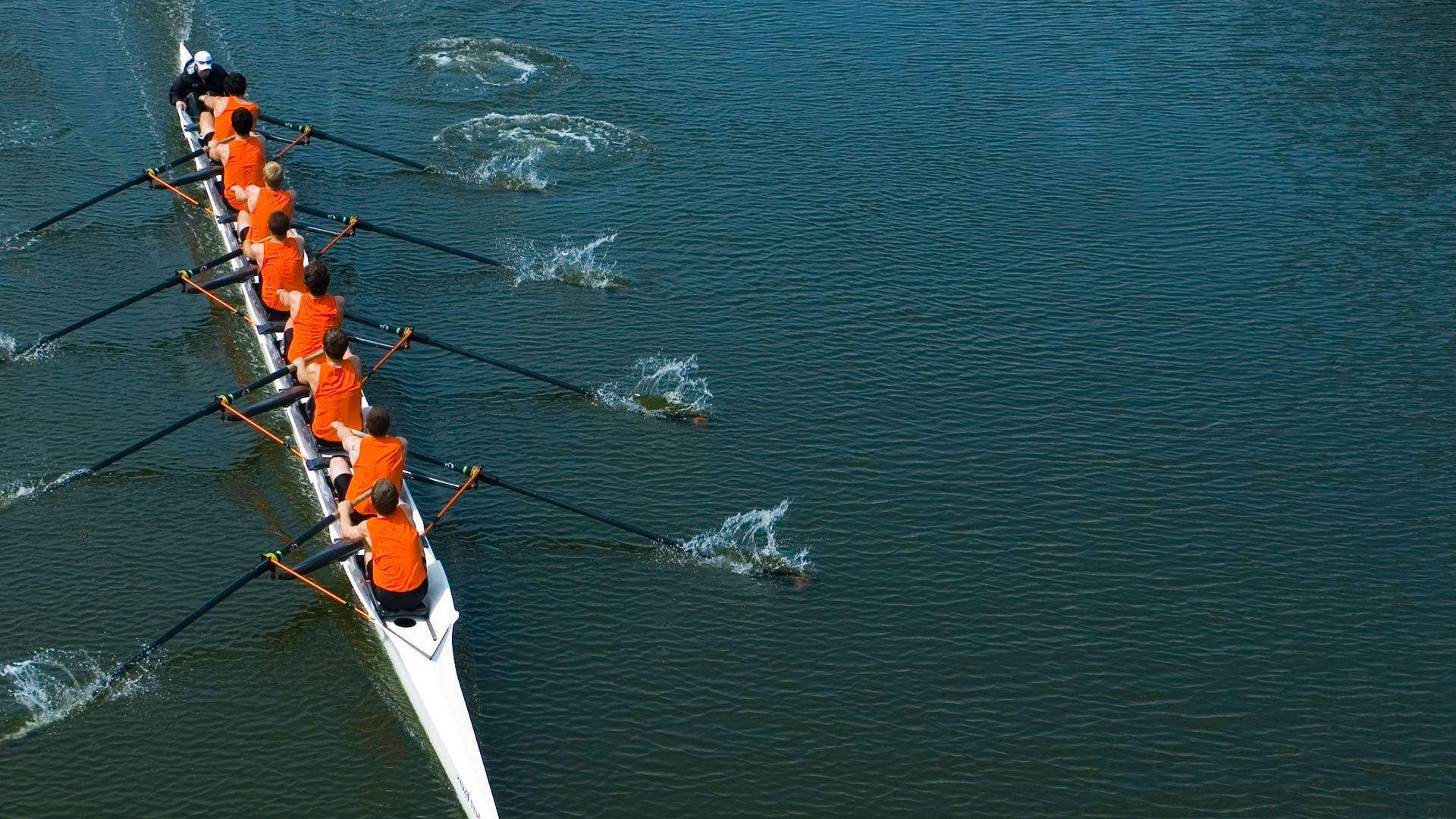 Determined Rowing Team in Action Wallpaper
