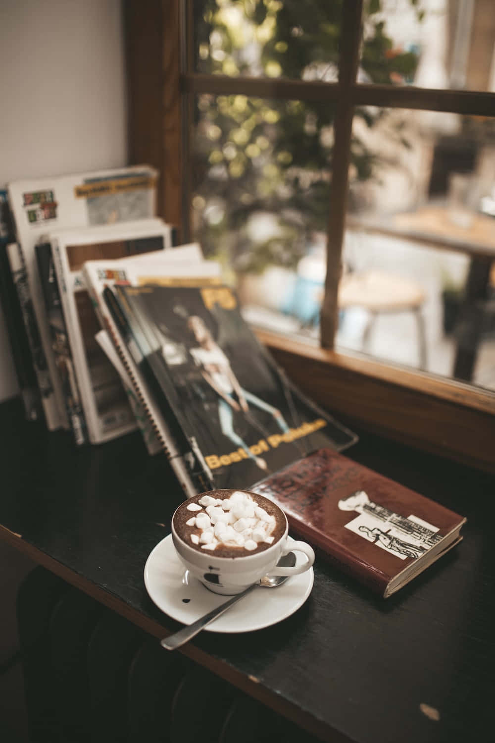 Unataza De Café Con Una Cuchara Y Revistas Sobre Una Mesa