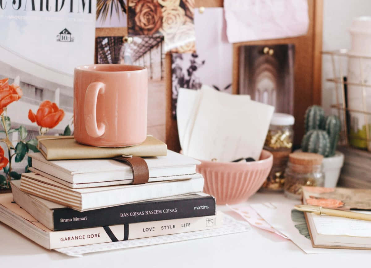 Cozy Desk Setupwith Booksand Coffee Mug Wallpaper