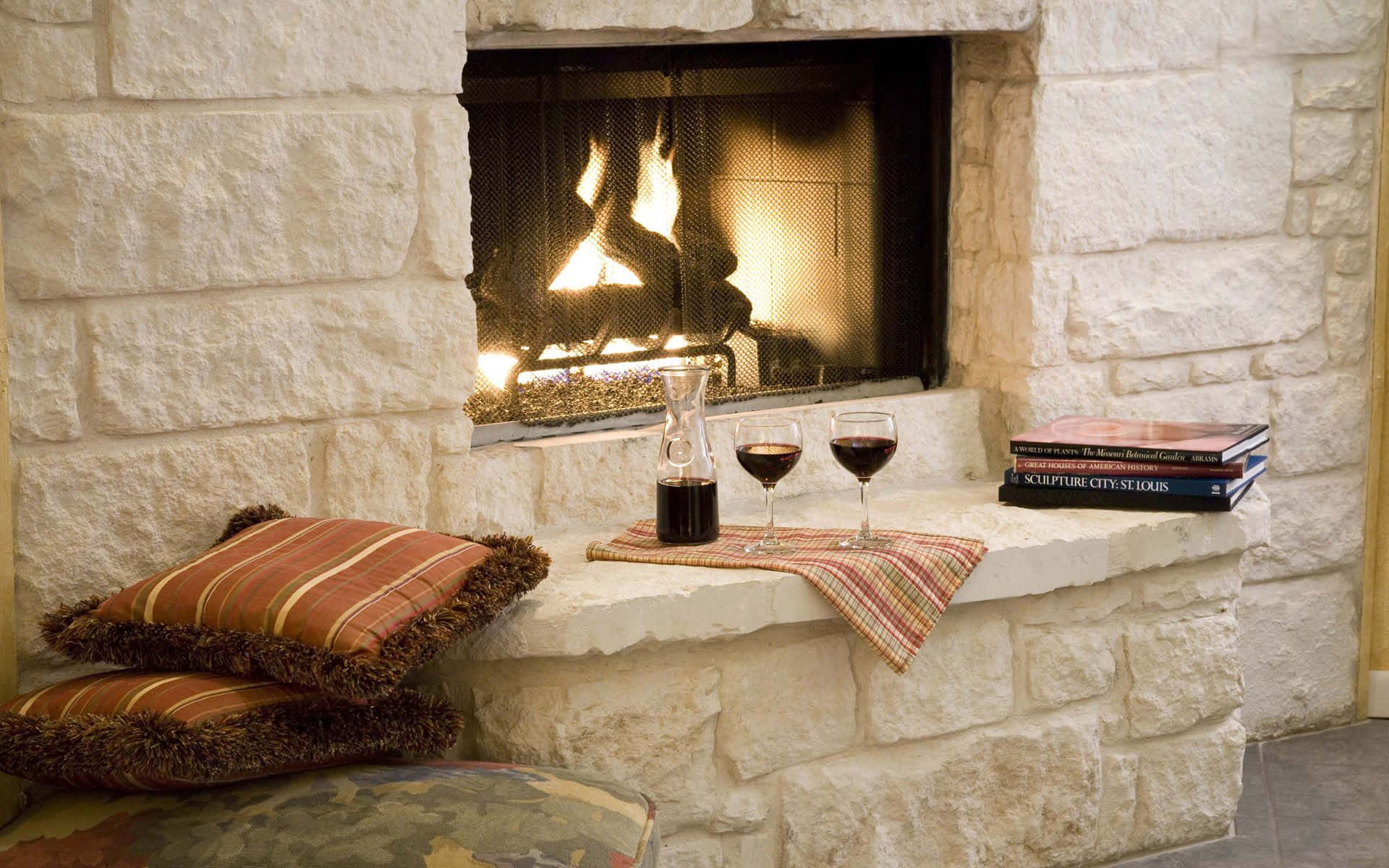 A Fireplace With A Book And Wine Wallpaper