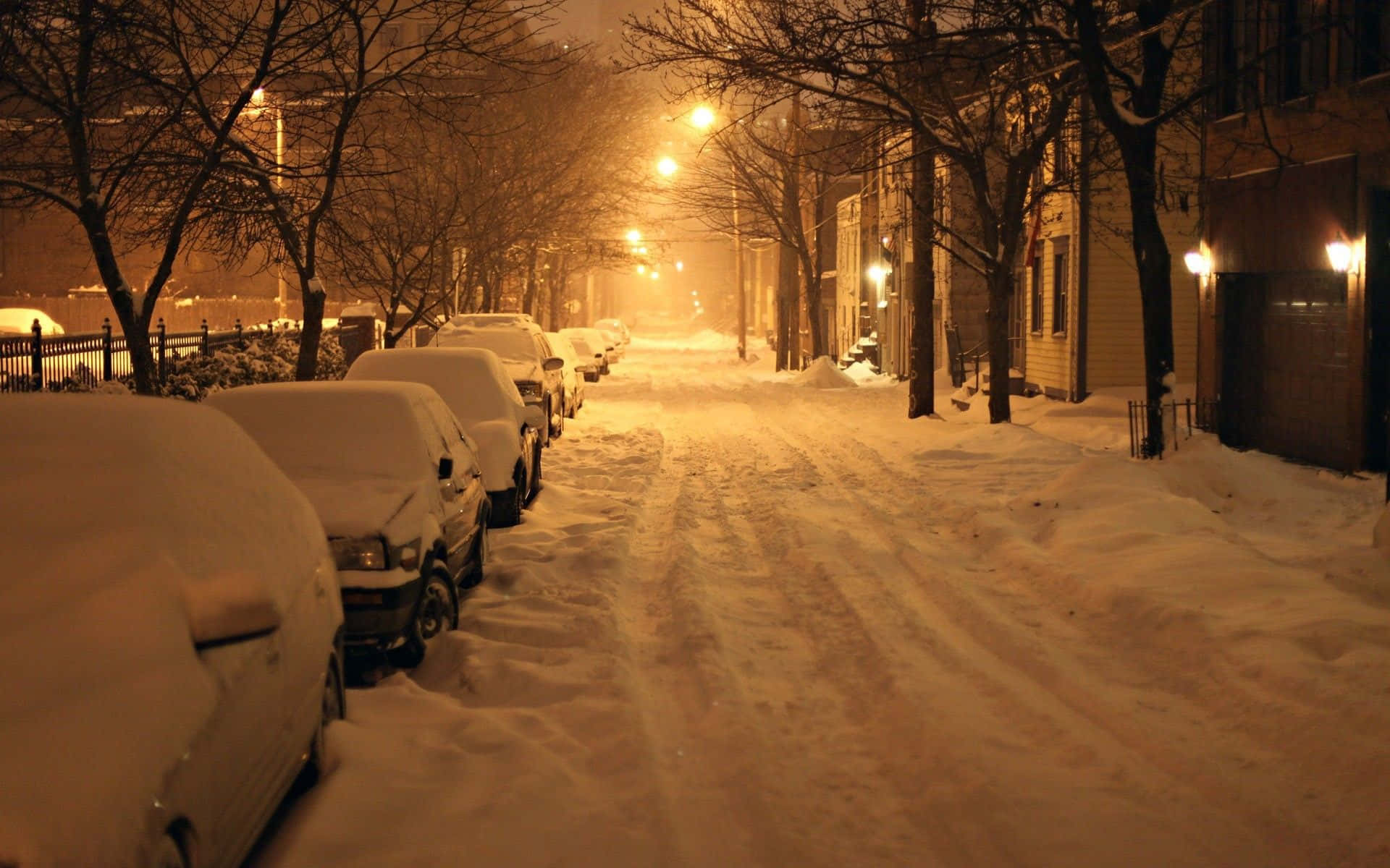 A Street With Cars Parked In The Snow Wallpaper