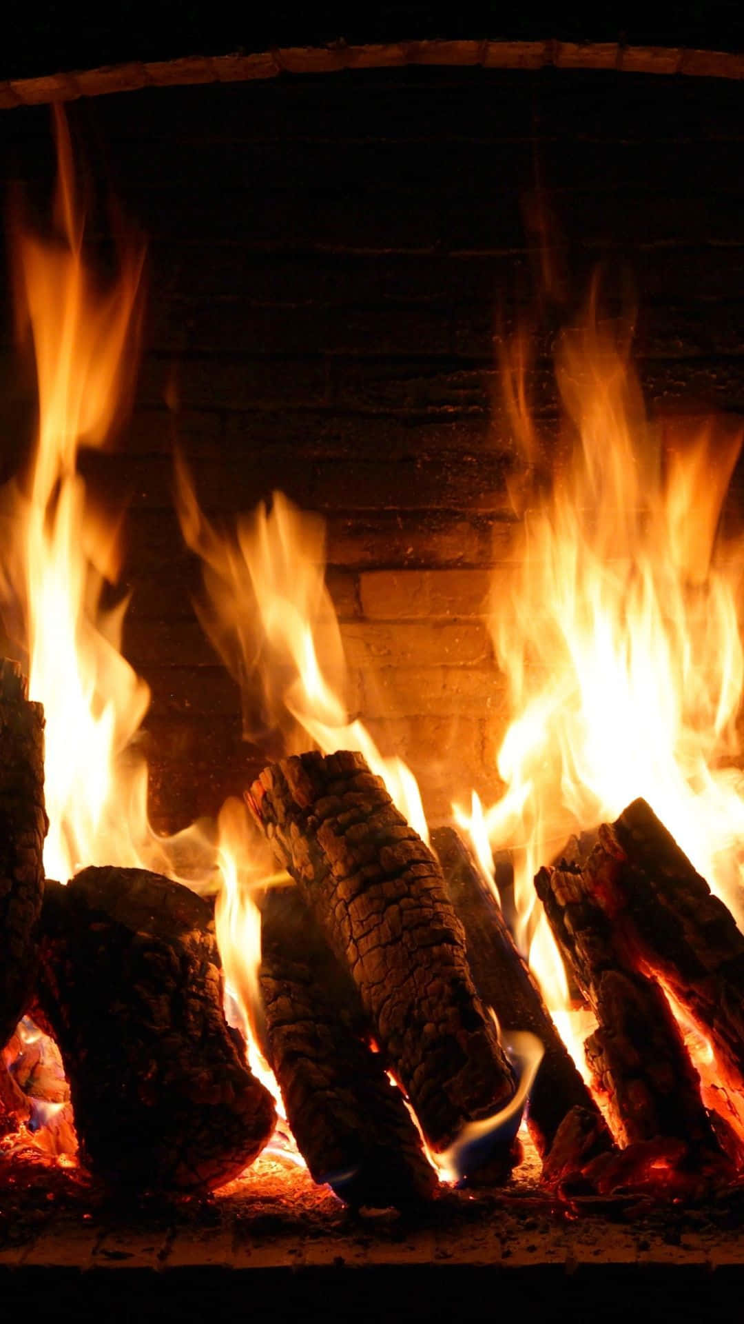 Ignite the Warmth - Cozy Fire in a Fireplace Wallpaper