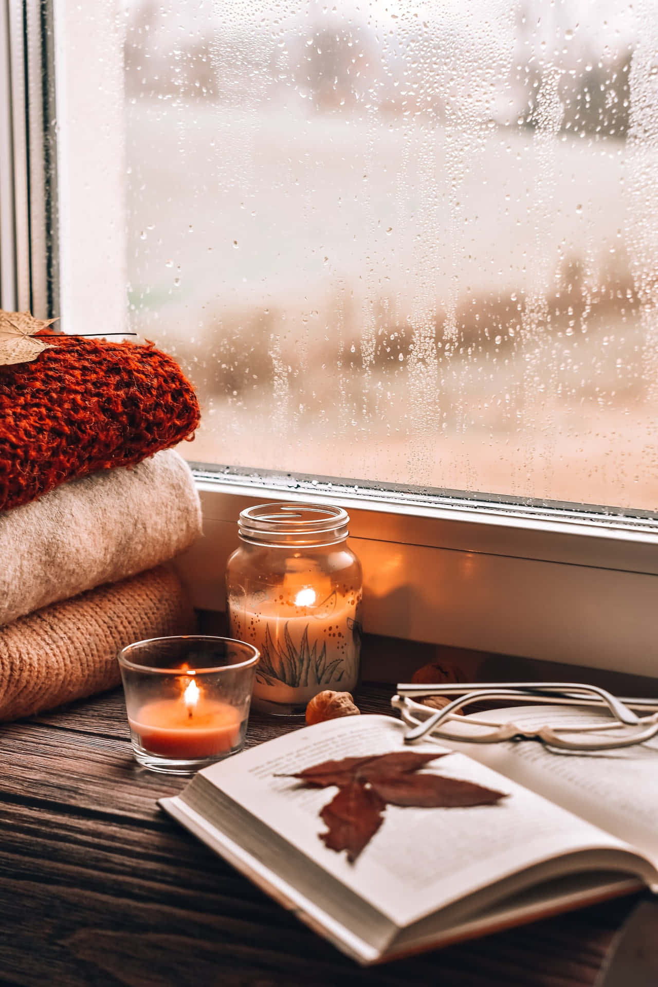 A Window With Candles, A Book, And A Blanket Wallpaper