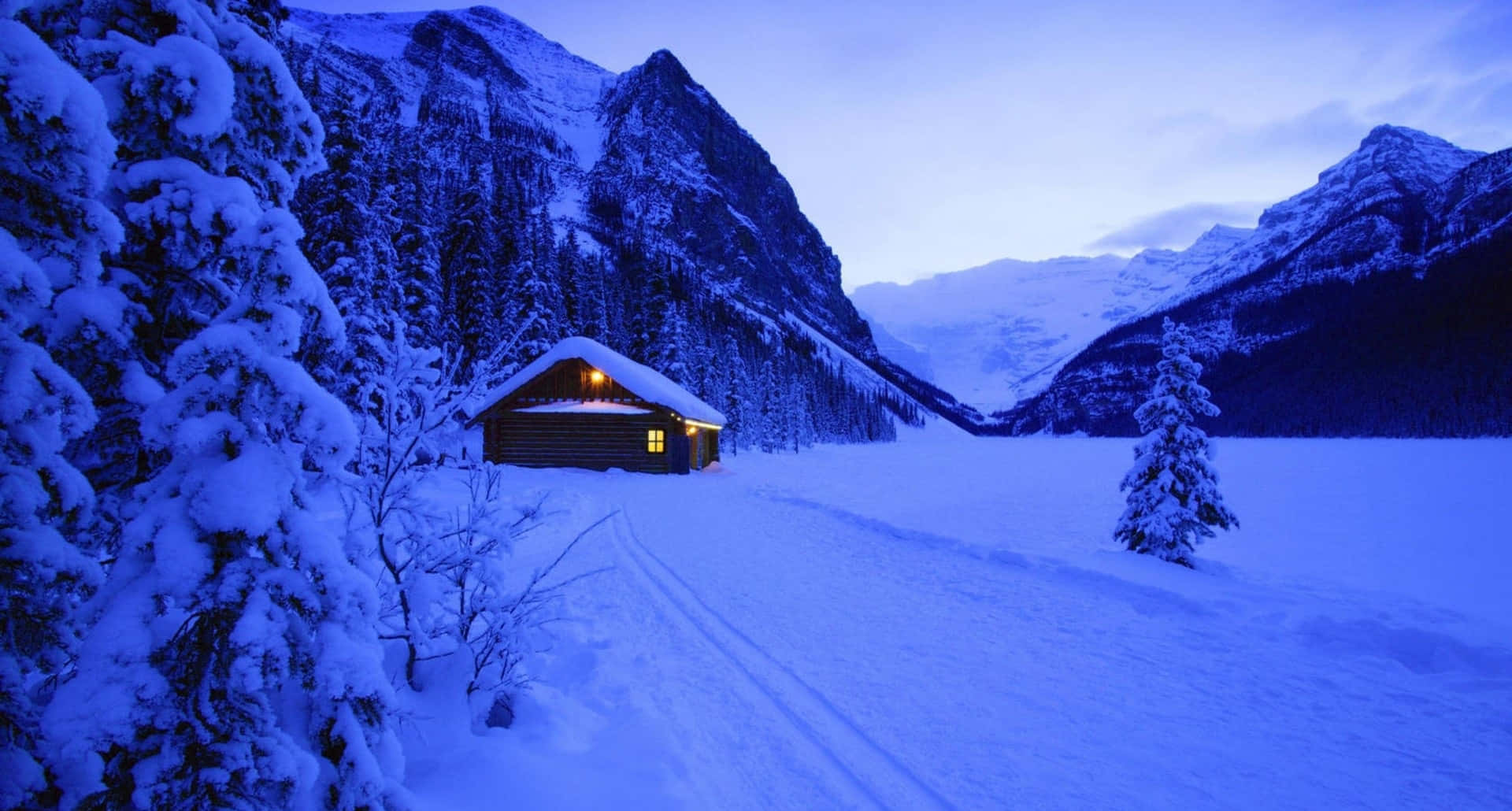 Scenic Cozy Winter Cabin Surrounded by Snowy Landscape Wallpaper