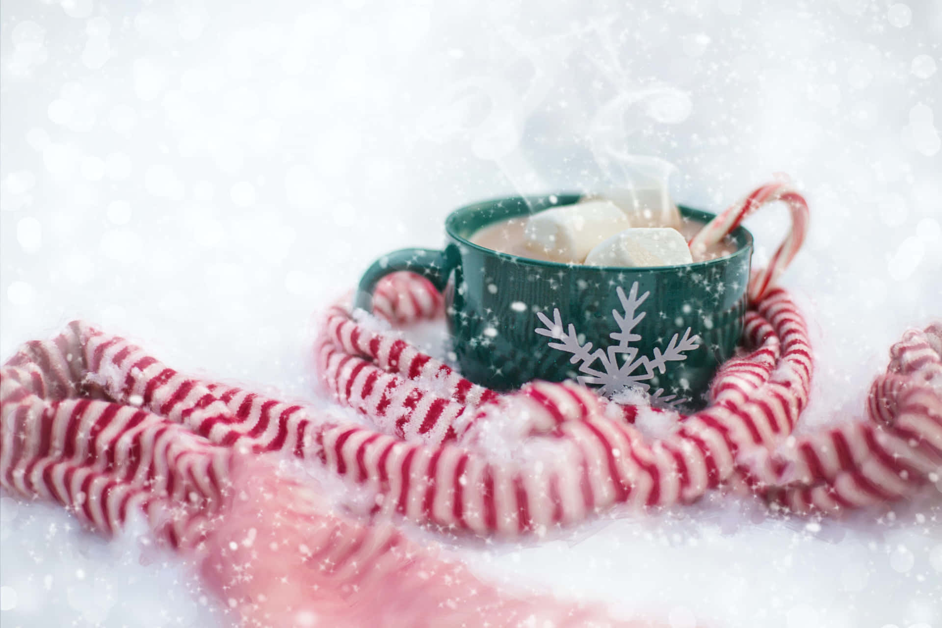 A Cup Of Hot Cocoa With Candy Canes On A Snowy Background Wallpaper