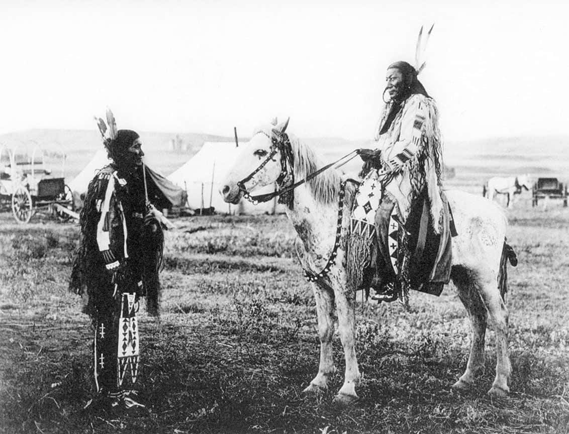 Two Native Americans Standing Next To Each Other