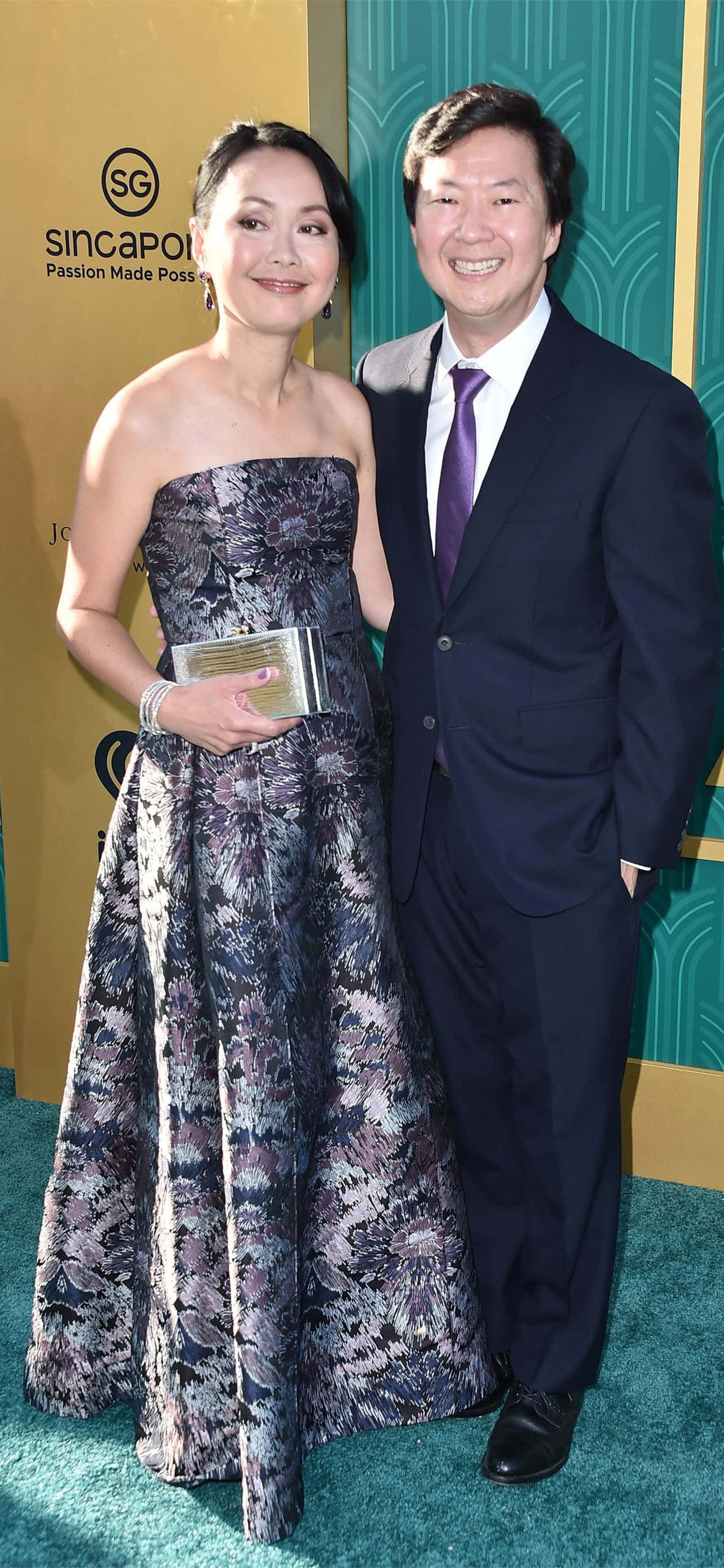 A Man And Woman Standing On A Green Carpet