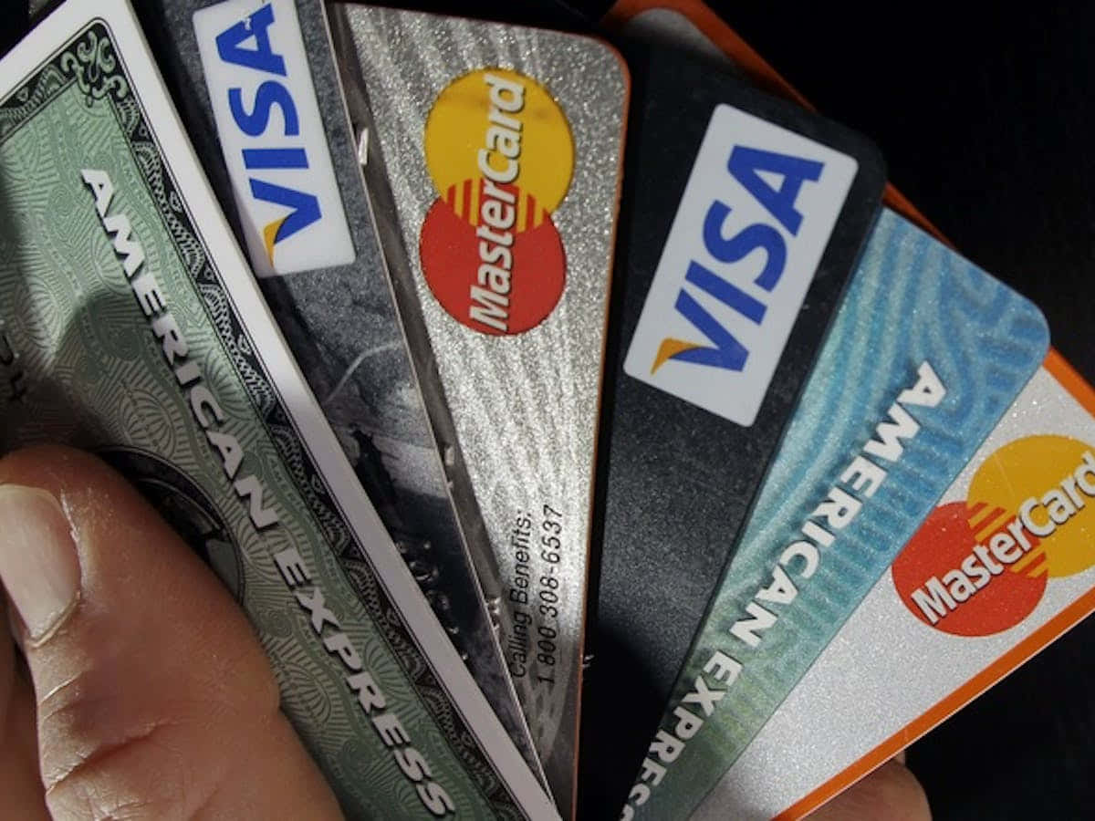 A Person Holding A Bunch Of Credit Cards