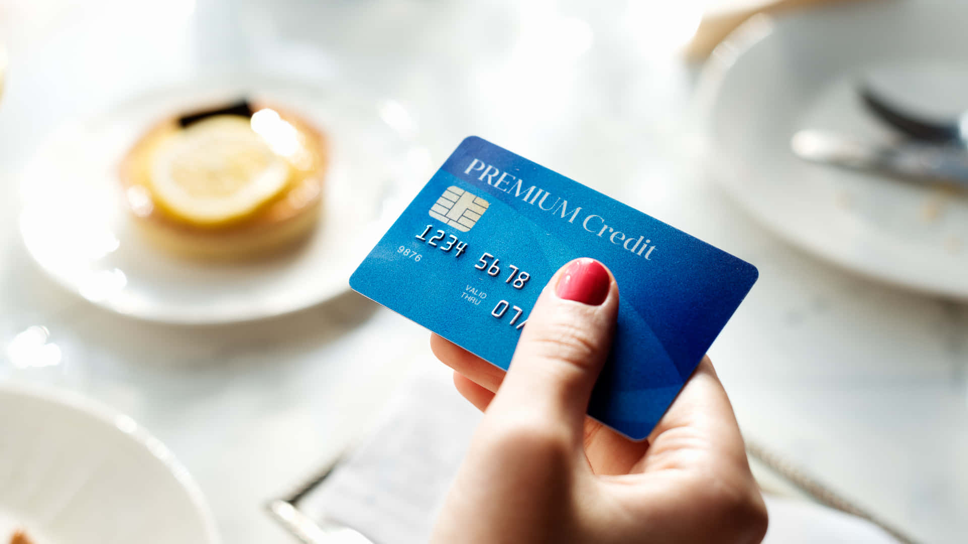 Umamulher Segurando Um Cartão De Crédito Na Frente De Uma Mesa